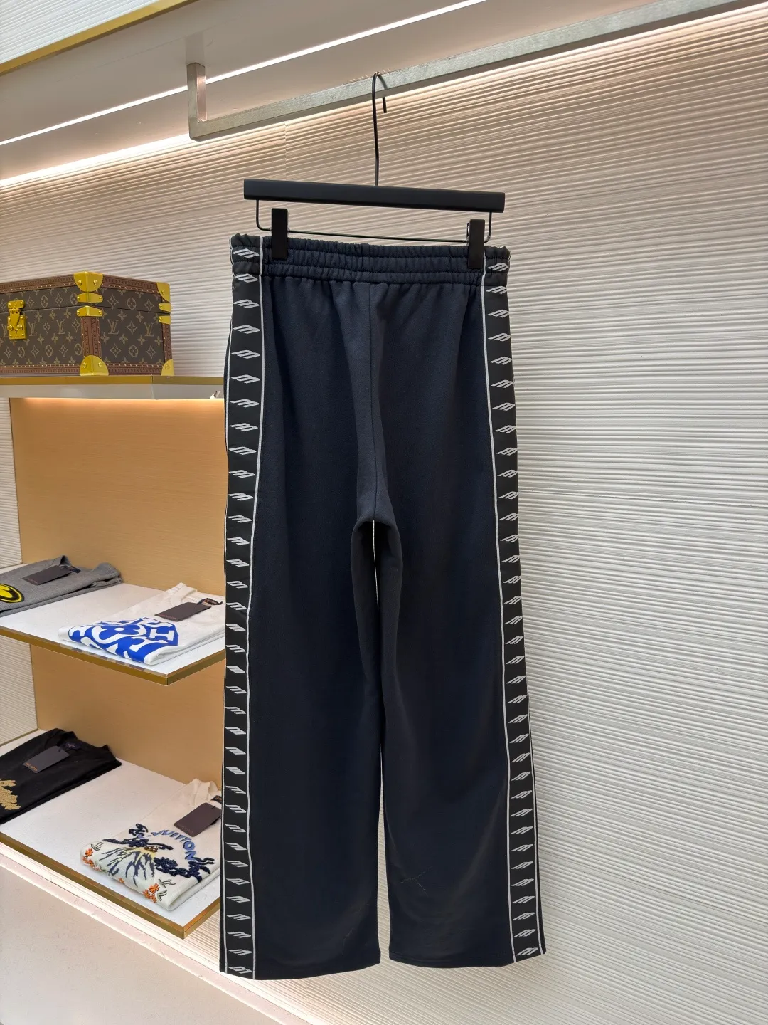 Balenciaga side webbing trousers ●Original version: Purchased and developed by 7858 ●Item number: 1682188-A95 ●Fabric: cotton fabric ●Technology: printing production ●Color: black ●Version: loose fit ●Weight: about 745 grams ●Size: XS-S-M-L ●Description: This black casual trousers with side straps shows ingenuity in craftsmanship. The trousers are made of high-density twill knitted fabric, which has undergone pre-shrunk treatment and high-temperature shaping process to ensure that the fabric is not easy to pill, deform and has an outstanding drape feeling. It also has good breathability and anti-wrinkle properties. The waist is designed with a high-elastic spandex drawstring, which is reinforced through precise four-line seaming technology. The drawstring perforations are equipped with metal air holes, which not only improves durability but also adds detailed texture. The side decorative belt is a custom-made jacquard webbing, woven with 72 stitches of high-density on a computerized jacquard machine. The pattern texture is clear and three-dimensional. The webbing and the trousers are spliced ​​together through a flat car synchronous sewing process. The stitches are even and fine and the spacing is controlled within 0.8cm, eliminating jumpers and off-thread problems. The trouser legs are hemmed using a seamless process and are reinforced with inner linings. The overall tailoring follows ergonomics and uses three-dimensional tailoring technology to make the trousers fit the body shape. Each process undergoes three quality control inspections. From fabric cutting to finished product sewing, dimensional accuracy and process details are strictly controlled throughout the process to create casual trousers with both texture and practical wearability. The overall wiring is straight and delicate, the fabric is comfortable and soft, and the color is consistent without color difference. It can be matched with the same style to create a fashionable look and control various occasions. Customized accessories, complete with three standards, same style for men and women!