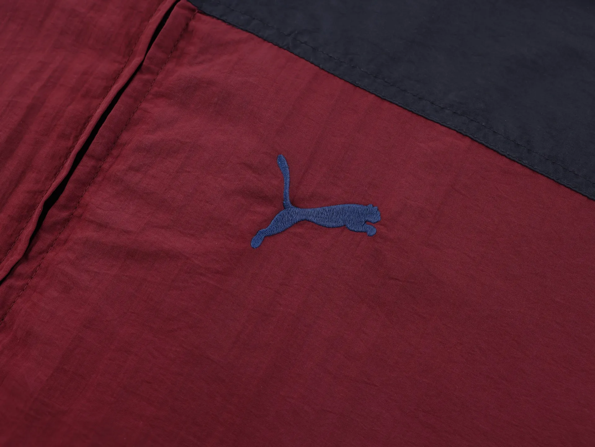 🅿️620 [Exclusive supply] BLCG x PUMA joint splicing distressed jacket. The surface of the fabric is made of polyester fiber sports fabric. This fabric is wear-resistant and washable, and is not easy to wrinkle in daily wear. The burgundy and navy blue splicing highlights the visual layering. The interior is made of cotton blended knitted fabric, making the upper body more skin-friendly and breathable. The navy blue splicing part adopts water-washed spray-on process. The main purpose of this process is to produce partial fading and natural distressing effect on the fabric through chemical action. The whole body is positioned to be hand-worn in design, which is very time-consuming and labor-intensive. The chest embroidery uses an imported Behringer embroidery machine, and uses matte lines to give the embroidery a more high-end texture. The classic string label on the side has a minimum order of 1,000 meters, custom-made engraved hardware zippers, and customized co-branded collar label accessories. Size:XS-S-M-L