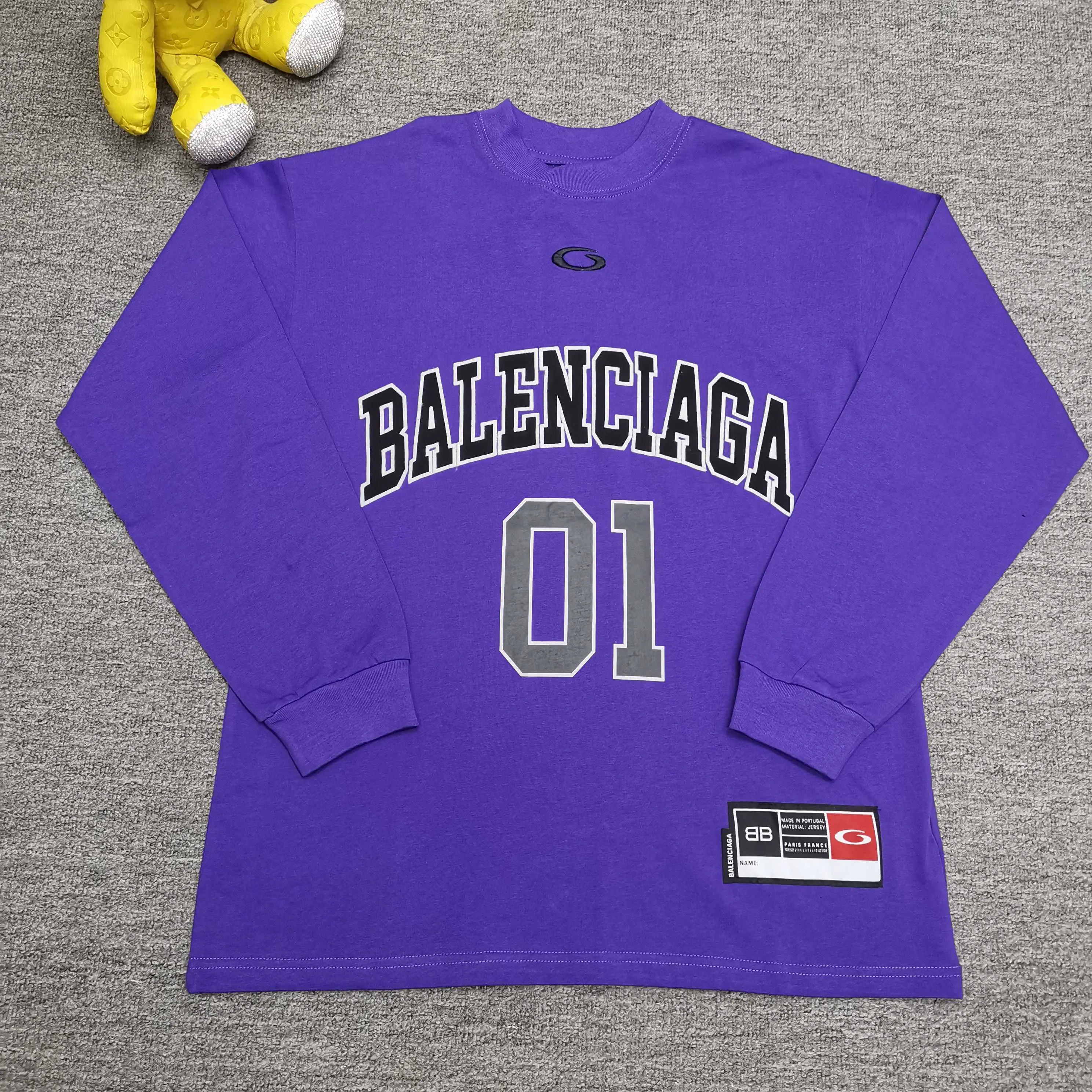[Top version. Official website quality] BALENCI*GA/Paris.SS25 latest basketball uniform embroidered printed long-sleeved T-shirt. The front embroidery is embroidered and printed using a Tajima computer embroidery machine, the lower left corner is stamped, and the back piece is printed. Brick cabinets are synchronized. Genuine products are developed at the first time. The fabric is made of Paris ZP custom-woven and dyed cotton double yarn. Weighing 260 grams, the cloth surface is clean. The cloth pattern is clear, soft and comfortable. The threads are dyed with no color difference. The printing uses environmentally friendly imported materials, the letters are clear and the effect is three-dimensional. The version adopts OS loose shoulder design. Same style for men and women. Color: black, white, purple, orchid. Size: XS S M L P350