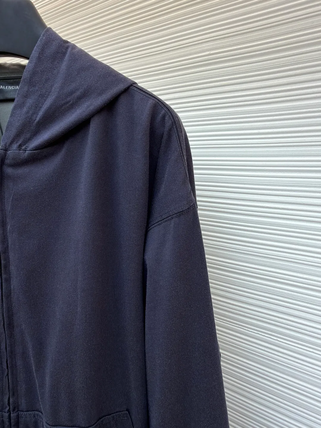 Balenciaga front and back double-layer hooded sweatshirt ●Original version: Purchased and developed by 9593 ●Item number: 1681294-B35 ●Fabric: Retro jersey fabric ●Technology: Washed production ●Color: black and gray ●Version: Loose version ●Weight: about 855 grams ●Size: Thread, weight is 270g. The weight of the fabric ensures lightness and breathability. The 24-count yarn gives the fabric a delicate and smooth texture, and the plain knitted structure brings good skin-friendliness and moderate elasticity. The fabric has been washed in faded gray, which not only gives it a unique retro look and softens the color, but also achieves a pre-softening effect on the touch, eliminating the stiffness of new fabric and giving the garment a comfortable and soft old material feel when worn for the first time. The main body of the gray surface embroidery adopts new tatami twill lace embroidery. The tatami embroidery stitches are intertwined and form diagonal lines. The tatami woven surface and the shaped edge integrally connected with the tatami woven surface. Good flatness, soft hand feel, good elasticity and good gloss. The woven surface of tatami is indented compared to the fixed edge, which improves the three-dimensional effect of the pattern and has a better visual effect. The black side uses precision needlepoint embroidery technology; the embroidery is very fine and dense, with clear patterns and strong lines and three-dimensionality. The linen material embroidery thread is combined with encrypted processing, and the embroidery body has a subtle matte visual texture; the embroidery effect is three-dimensional and full. The flat embroidery has a unique needle-to-needle design, and the embroidery is very fine and dense. The overall stitching is fine, with consistent fineness and texture, adding a sense of layering to the simple design. A unique technology that simulates natural aging through post-finishing processes. Through controlled stone grinding, enzyme washing and other processes, the original dye in the cotton fiber is partially removed, forming uneven fading marks on the dark base, thereby creating a soft, retro grayscale visual effect. The overall wiring is straight and delicate, the fabric is comfortable and soft, and the color is consistent without color difference. It can be matched with the same style to create a fashionable look and control various occasions. Customized accessories, complete with three standards, same style for men and women!