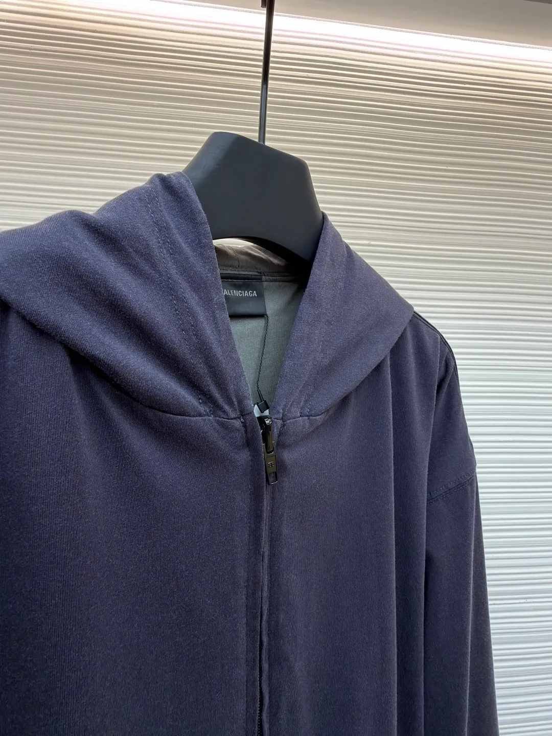 Balenciaga front and back double-layer hooded sweatshirt ●Original version: Purchased and developed by 9593 ●Item number: 1681294-B35 ●Fabric: Retro jersey fabric ●Technology: Washed production ●Color: black and gray ●Version: Loose version ●Weight: about 855 grams ●Size: Thread, weight is 270g. The weight of the fabric ensures lightness and breathability. The 24-count yarn gives the fabric a delicate and smooth texture, and the plain knitted structure brings good skin-friendliness and moderate elasticity. The fabric has been washed in faded gray, which not only gives it a unique retro look and softens the color, but also achieves a pre-softening effect on the touch, eliminating the stiffness of new fabric and giving the garment a comfortable and soft old material feel when worn for the first time. The main body of the gray surface embroidery adopts new tatami twill lace embroidery. The tatami embroidery stitches are intertwined and form diagonal lines. The tatami woven surface and the shaped edge integrally connected with the tatami woven surface. Good flatness, soft hand feel, good elasticity and good gloss. The woven surface of tatami is indented compared to the fixed edge, which improves the three-dimensional effect of the pattern and has a better visual effect. The black side uses precision needlepoint embroidery technology; the embroidery is very fine and dense, with clear patterns and strong lines and three-dimensionality. The linen material embroidery thread is combined with encrypted processing, and the embroidery body has a subtle matte visual texture; the embroidery effect is three-dimensional and full. The flat embroidery has a unique needle-to-needle design, and the embroidery is very fine and dense. The overall stitching is fine, with consistent fineness and texture, adding a sense of layering to the simple design. A unique technology that simulates natural aging through post-finishing processes. Through controlled stone grinding, enzyme washing and other processes, the original dye in the cotton fiber is partially removed, forming uneven fading marks on the dark base, thereby creating a soft, retro grayscale visual effect. The overall wiring is straight and delicate, the fabric is comfortable and soft, and the color is consistent without color difference. It can be matched with the same style to create a fashionable look and control various occasions. Customized accessories, complete with three standards, same style for men and women!