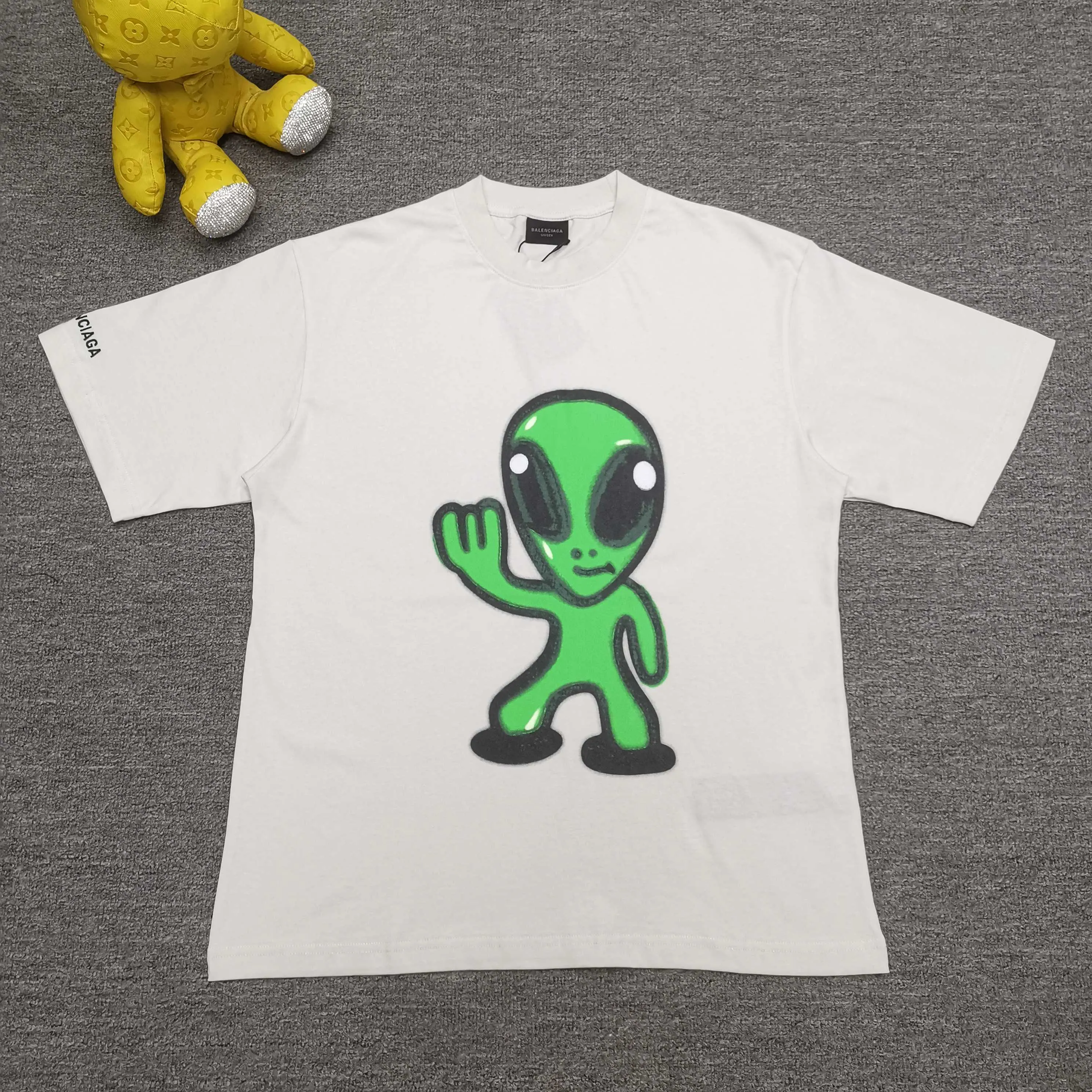 [Top version. Official website quality] BALENCI*GA/25 new style. The front is directly printed with hithg there + dripley art work + luminous effect, aliens are printed on the front, smiley faces are printed on the back, short-sleeved T-shirt with embroidered letters on the right sleeve # SS25 latest style. Research and development at the first time, different market currencies. Comparisons welcome. The fabric is made of Paris ZP custom-woven and dyed cotton double yarn. Weighing 260 grams, the cloth surface is clean. The cloth pattern is clear, soft and comfortable. The threads are dyed with no color difference. Printing adopts computer direct printing. Jubie market currency. Welcome to compare. The version adopts OS loose shoulder design. Same style for men and women. Color: off-white, black, floral gray. Size: XS S M L P260