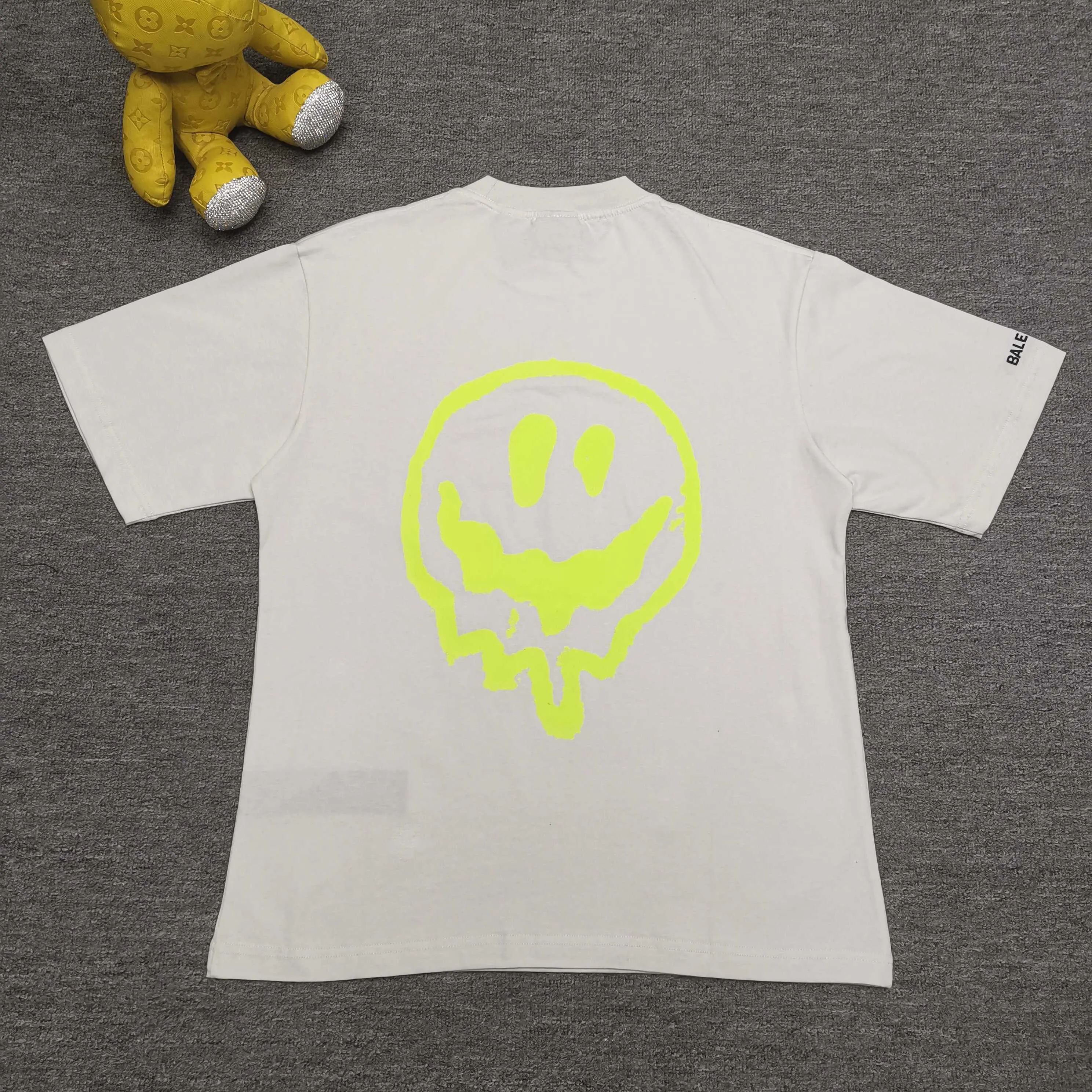 [Top version. Official website quality] BALENCI*GA/25 new style. The front is directly printed with hithg there + dripley art work + luminous effect, aliens are printed on the front, smiley faces are printed on the back, short-sleeved T-shirt with embroidered letters on the right sleeve # SS25 latest style. Research and development at the first time, different market currencies. Comparisons welcome. The fabric is made of Paris ZP custom-woven and dyed cotton double yarn. Weighing 260 grams, the cloth surface is clean. The cloth pattern is clear, soft and comfortable. The threads are dyed with no color difference. Printing adopts computer direct printing. Jubie market currency. Welcome to compare. The version adopts OS loose shoulder design. Same style for men and women. Color: off-white, black, floral gray. Size: XS S M L P260