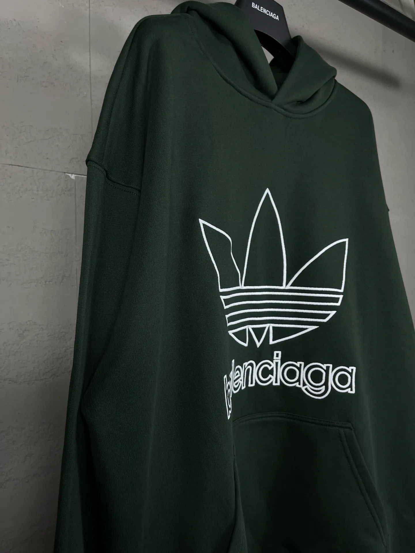 🅿️300 Detailed picture [Top version. Official website quality] BALENCI*GA/Paris co-branded Adidas embroidered front LOGO long-sleeved hooded sweatshirt. The fabric is made of Paris ZP custom-woven and dyed cotton sweatshirt. The weight is 450 grams, the cloth surface is clean. The cloth pattern is clear, soft and comfortable. The color fastness is good. It is not easy to change color. The threads are dyed with no color difference. The LOGO pattern letters are embroidered using imported embroidery machines, and the letters are three-dimensional and full. It is produced in Jubie market based on pictures, and comparisons are welcome. Restored brick cabinets. The version adopts OS loose shoulder design. Same style for men and women. Code: BL238017 Color: dark green, black Size: XS S M L