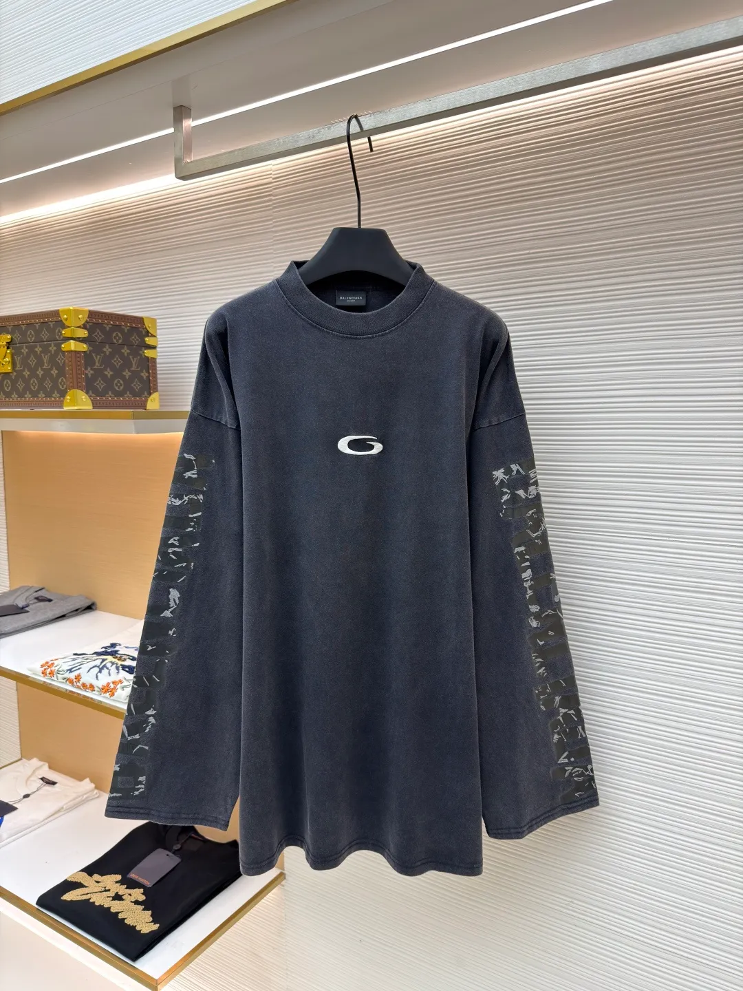 Balenciaga tape letter long sleeves ●Original version: Purchased and developed by 4229 ●Item number: 1681163-A55 ●Fabric: Heavy combed cotton fabric ●Technology: Made of fried salt for ready-to-wear ●Color: black ●Version: loose fit ●Weight: about 475 grams ●Size: XS-S-M-L ●Description: Custom-woven and dyed 240 grams of heavy combed cotton. This weight makes the garment extremely crisp, not easy to wrinkle, and has excellent drape. It avoids the shortcomings of cheap T-shirts that are thin, transparent and easy to deform. It can always maintain a neat outline and a thick and solid texture when worn. During the spinning process, the shorter cotton fibers and impurities are removed through a "combing" process, leaving only long and neat high-quality cotton fibers. The yarn spun in this way is stronger and smoother, and the fabric woven has a delicate and smooth feel, is less prone to pilling, and has better durability and gloss. Embroidery is performed using a Tajima machine, and the stitch density is carefully designed to ensure that the pattern is clear and three-dimensional, while matching the heavy texture of the heavy fabric without appearing frivolous. The direction and finish of each stitch reflect the level of craftsmanship. The salt-fried process for garments is a physical distressing treatment. Ready-made garments are placed into large industrial drums along with special, screened salt or mineral particles and tumbled and agitated for varying times and intensities. By "fried salt," the salt grains are continuously and randomly rubbed against the cotton fibers, resulting in an extremely natural, uneven fading effect, subtle wrinkle texture (not wrinkles, but texture) on the surface of the fabric, and a unique soft touch. This aged effect cannot be accurately replicated by machines, and each piece is unique. Using special printing pigments, mixed with liquid silicone oil compound. Craftsmen apply this special silicone oil compound to the surface of the fabric by hand through a silk screen template. Subsequently, the garment needs to be baked or cured at a certain temperature to combine the silicone oil with the cotton fibers. The overall wiring is straight and delicate, the fabric is comfortable and soft, and the color is consistent without color difference. It can be matched with the same style to create a fashionable look and control various occasions. Customized accessories, complete with three standards, same style for men and women!