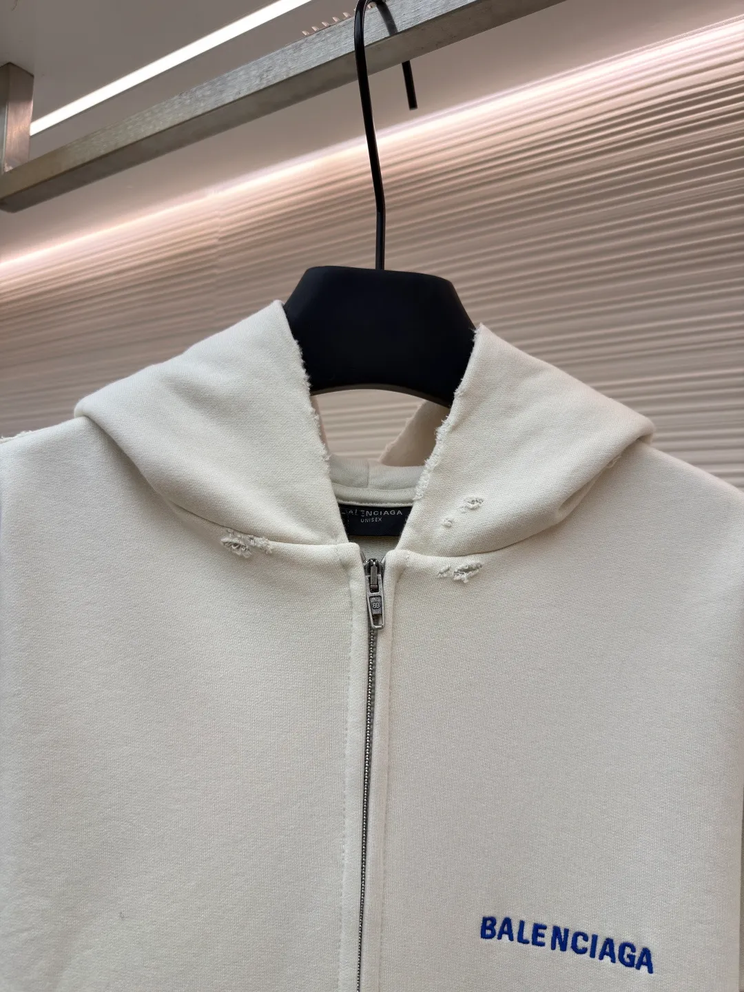 Balenciaga letter embroidered hooded zipper long-sleeved sweatshirt ●Original version: Purchased and developed for 9200 ●Item number: 1682263-A95 ●Fabric: combed cotton ●Technology: Washed and frayed ●Color: white ●Version: loose fit ●Weight: about 965 grams ●Size: S-M-L ●Description: This Balenciaga letter embroidered hooded zipper sweatshirt is made of 380g heavyweight pure cotton terry cloth, which has been treated with enzyme washing process. The fabric has a natural old-fashioned soft and waxy texture. At the same time, the stone grinding process is used to create irregular raw edge effects on the cuffs and hem, restoring the retro street style. The body adopts a loose, dropped-shoulder version, and the three-dimensional tailoring makes the shoulder lines smooth. The hooded part has a built-in drawstring made of pure cotton and is pre-shrunk to prevent it from deforming. The custom-made metal zipper on the front zipper closes smoothly and has no lag after repeated opening and closing tests. The brand letters on the left chest are made with imported embroidery machines using flat embroidery stitches, using polyester thread with high color fastness. The stitches are fine and neat without skipping, and the letter outline is three-dimensional and clear. The overall stitching uses double-needle overlocking technology, with up to 12 stitches per inch. The ribbed edges on the cuffs and hem are made of spandex blended material, which has long-lasting elasticity and is not easy to loosen, taking into account both wearing comfort and stiffness. The overall wiring is straight and delicate, the fabric is comfortable and soft, and the color is consistent without color difference. It can be matched with the same style to create a fashionable look and control various occasions. Customized accessories, complete with three standards, same style for men and women!