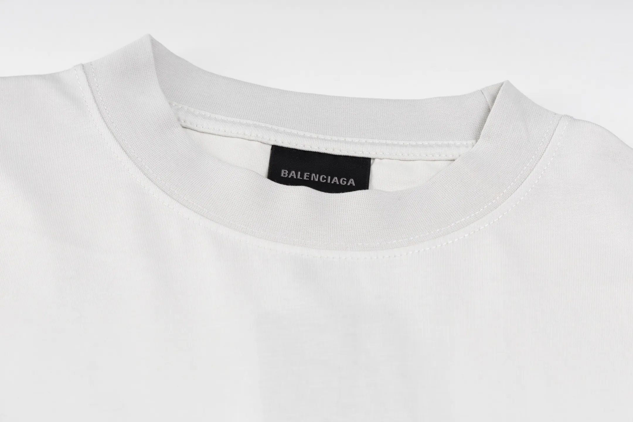 🅿️290 Exclusive supply] BLCG 25FW badge printed short sleeves (white) The fabric is made of 24S 185g double yarn special textile compact cotton, and the rib is made of 32S 340g double yarn stretch rib. The structure of pure cotton fabric is plain weave. The surface of the fabric is smooth and delicate, and the texture is tight. It has good moisture absorption, breathability and comfort, and can keep you dry and comfortable. Due to its tight spinning process, it also has good wrinkle resistance and durability, making it suitable for long-term wear or use. The multi-layer superposition process of dark flower paste dots uses precision screen technology to cover the fabric with translucent printing paste through multiple layered printing. Each layer is laminated and fused with micron-level tolerances. Through subtle changes in the thickness and density of the slurry, an invisible pattern with a transition between dark and light is formed on the surface of the fabric. This technology replaces color contrast with physical accumulation, and uses the diffuse reflection of light on concave and convex surfaces to present a looming light and shadow relief effect, creating a high-end print with both visual haziness and tactile three-dimensionality, which perfectly fits the low-key and luxurious design aesthetics. Size:XS-S-M-L