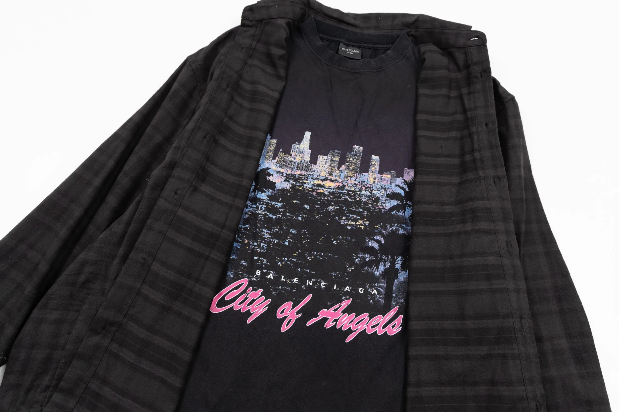 🅿️720 BLCG 25FW night scene plaid genuine two-piece spliced ​​jacket. The shirt fabric is made of custom blended plaid jacquard woven fabric, the T-shirt fabric is made of 24S 185g double yarn special textile compact cotton fabric, and the T-shirt rib is made of 32S 340g double yarn stretch rib. The two-piece set of lapel shirts integrates craftsmanship and dialogues with style through the four pillars of composite structure design, difficult screen printing, sophisticated detail processing and overall distressed finishing. It achieves the diverse unity of style and function, retro and contemporary, luxury and casualness in one single product; it redefines the wearing possibilities of modern shirts. Its core value lies in the groundbreaking "two-piece" composite structure, which perfectly combines the rigor of woven with the flexibility of knitting. The outer shirt is made of cotton poplin, which uses its tight weave structure to bring a smooth surface and crisp bones, creating a smart outer silhouette; the inner part integrates a vintage jersey short sleeve, which uses its natural elasticity and softness to provide unparalleled personal comfort. The interior is printed with front artwork, and the night scene pattern is printed using multi-screen environmentally friendly oil-based dark floral paste. The richness of pattern colors and the precision of details are combined with the use of environmentally friendly oily dark flower paste materials. The special glue can form a light and strong coating after printing. The pattern presents a matte and slightly three-dimensional dark flower effect, which is smooth to the touch without the stickiness and hardening of traditional offset printing, which greatly ensures the wearing comfort and the durability of the pattern. The exterior shirt's crisp lapels, functional chest patch pockets, and exposed rounded hem create a simple yet sophisticated base. Engraved logo buttons, custom accessories with finely engraved logo. Through professional post-finishing processes such as enzyme washing and stone grinding, the garments are softened and micro-abraded as a whole, giving cotton poplin and knitted fabrics a uniform gentle fading and soft touch, imitating the unique texture formed after years of wearing. Size:1-2-3-4