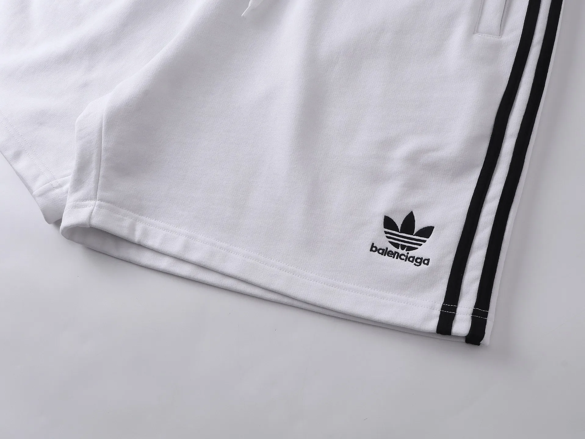 🅿️240 real shots [Top version. Official website quality] BALENCI*GA/Paris. 2025 new model. Paris co-branded adidas clover embroidered side seams. Invisible zipper shorts at the pocket. Brick cabinet synchronization. Genuine product developed at the first time, please print and compare! The fabric is made of Paris ZP custom-woven and dyed 100% cotton terry sweatshirt. The weight is 460 grams. The cloth surface is clean. The cloth pattern is clear and the hand feels soft and comfortable. The embroidery uses an imported Tajima embroidery machine. The letters are clear and the effect is three-dimensional. The version adopts a loose version. Same style for men and women. Code: BL257029 Color: black, white Size: XS S M L