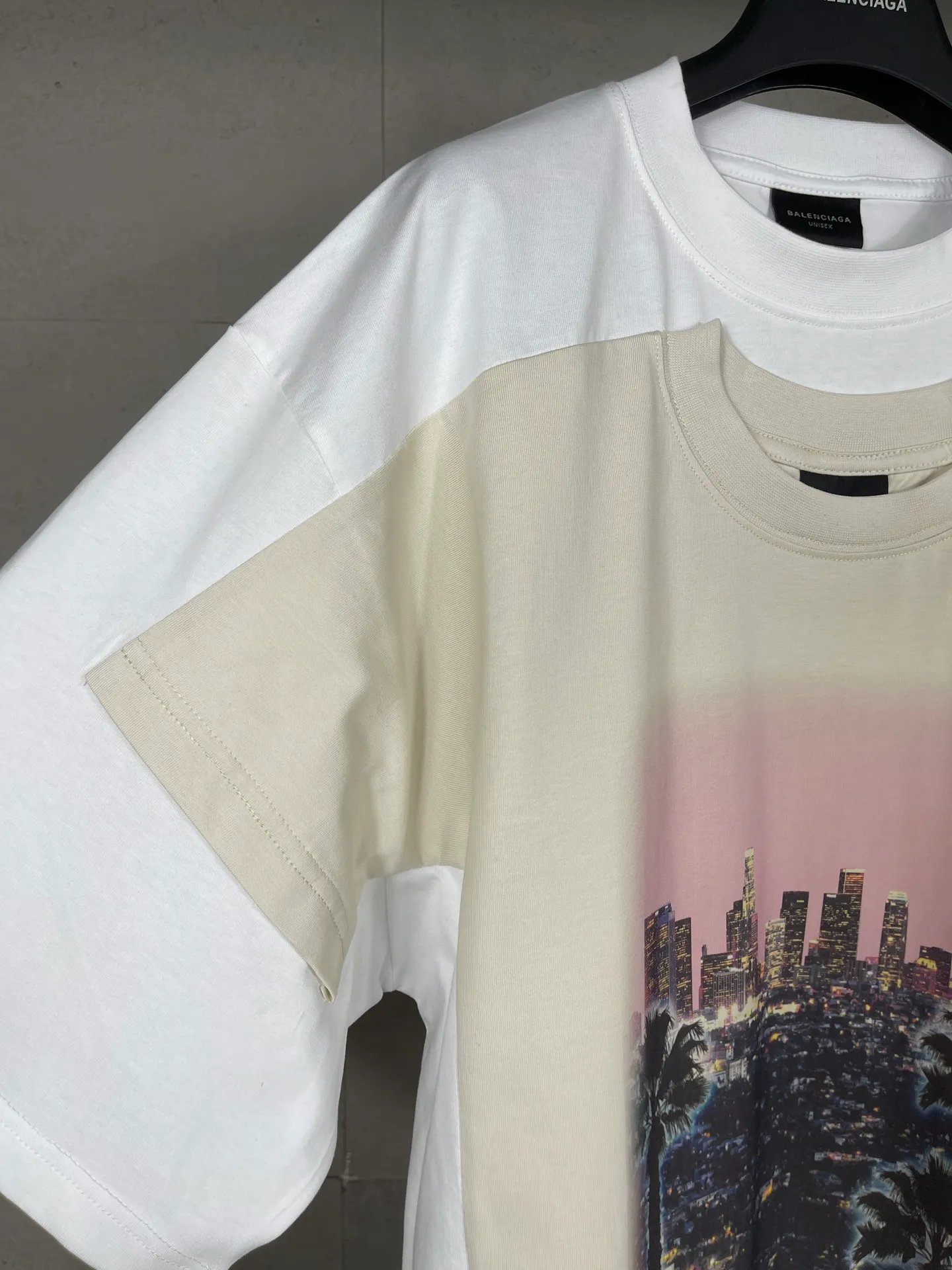 🅿️226 Actual pictures [Top version. Official website quality] BALENCI*GA/25 new model. The front is directly printed with the Los Angeles night scene, overlapping double-layer short-sleeved T-shirt #overlapping dark line stitching, the latest SS25 style with super heavy craftsmanship. Research and development at the first time, different market currencies. Comparisons welcome. The fabric is made of Paris ZP custom-woven and dyed cotton double yarn. Weighing 260 grams, the cloth surface is clean. The cloth pattern is clear, soft and comfortable. The threads are dyed with no color difference. Printing adopts computer direct printing. Jubie market currency. Welcome to compare. The version adopts OS loose shoulder design. Same style for men and women. Code: BL253710 Color: White Size: XS S M L
