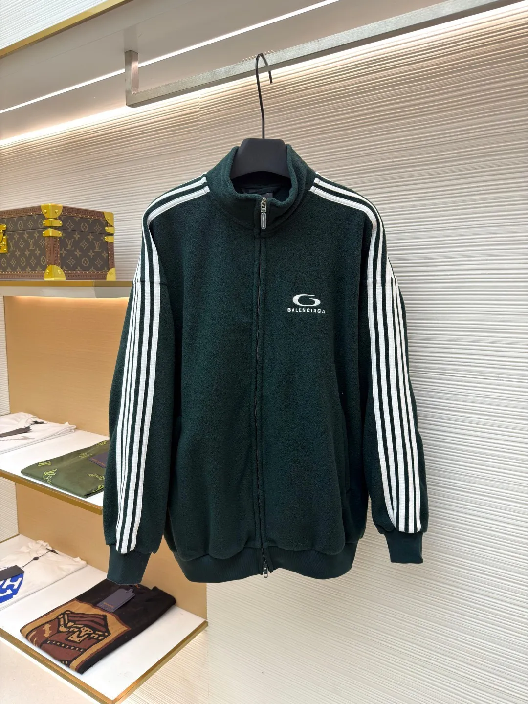 Balenciaga stand-up collar zipper jacket with embroidered sleeves ●Original version: Purchased and developed for 16500 ●Item number: 1680949-B25 ●Fabric: polar fleece fabric ●Technology: knitted production ●Version: Loose fit ●Weight: about 735 grams ●Size: XS-S-M-L ●Description: High-performance polar fleece knitted fabric is known for its excellent warmth retention and light texture. Through a special brushing process, a dense and rich velvet structure is formed on the surface of the fabric, which effectively locks in still air and achieves efficient heat insulation. The warmth retention per unit weight is better than that of traditional knitted materials. At the same time, its fiber gaps ensure that moisture can be exported in time, taking into account breathability. The fabric is usually treated with anti-static and water-repellent treatments to enhance practical functions, and has excellent ductility and anti-pilling properties. It feels soft and fluffy, and does not feel restrictive when moving. Using high-density stitching and multi-color embroidery thread, the pattern has clear edges and three-dimensional fullness; it is made with the overall tatami embroidery technology. To customize the embroidery thread material according to the pattern and color, you need to choose a suitable rice mat as the base material for embroidery to ensure that its surface is flat, smooth and suitable for embroidery. Draw line outlines on the fabric according to the embroidery pattern so that the outline can be accurately followed during embroidery. The contrasting piping on the sleeves is precisely stitched with hemming technology to strengthen the contour lines and improve wear resistance; the solid color fabric and white contrasting design enhance the visual impact. The gathered cuffs and waist are made of high-elastic rib material to enhance the fit and prevent the intrusion of cold wind. It is equipped with a double-ended zipper to achieve flexible opening and closing. The two zippered diagonal pockets take into account storage security and smooth styling, reflecting practical details. The silhouette is both unisex and unisex, with a gathered waist and straight body that balances looseness and slim fit. The high collar design extends the neck protection, echoing the theme of sports protection; the overall minimalist outline highlights the visual focus of embroidery and piping, transforming functional details into design elements, perfectly integrating sports genes and street art style. The overall wiring is straight and delicate, the fabric is comfortable and soft, and the color is consistent without color difference. It can be matched with the same style to create a fashionable look and control various occasions. Customized accessories, complete with three standards, same style for men and women!