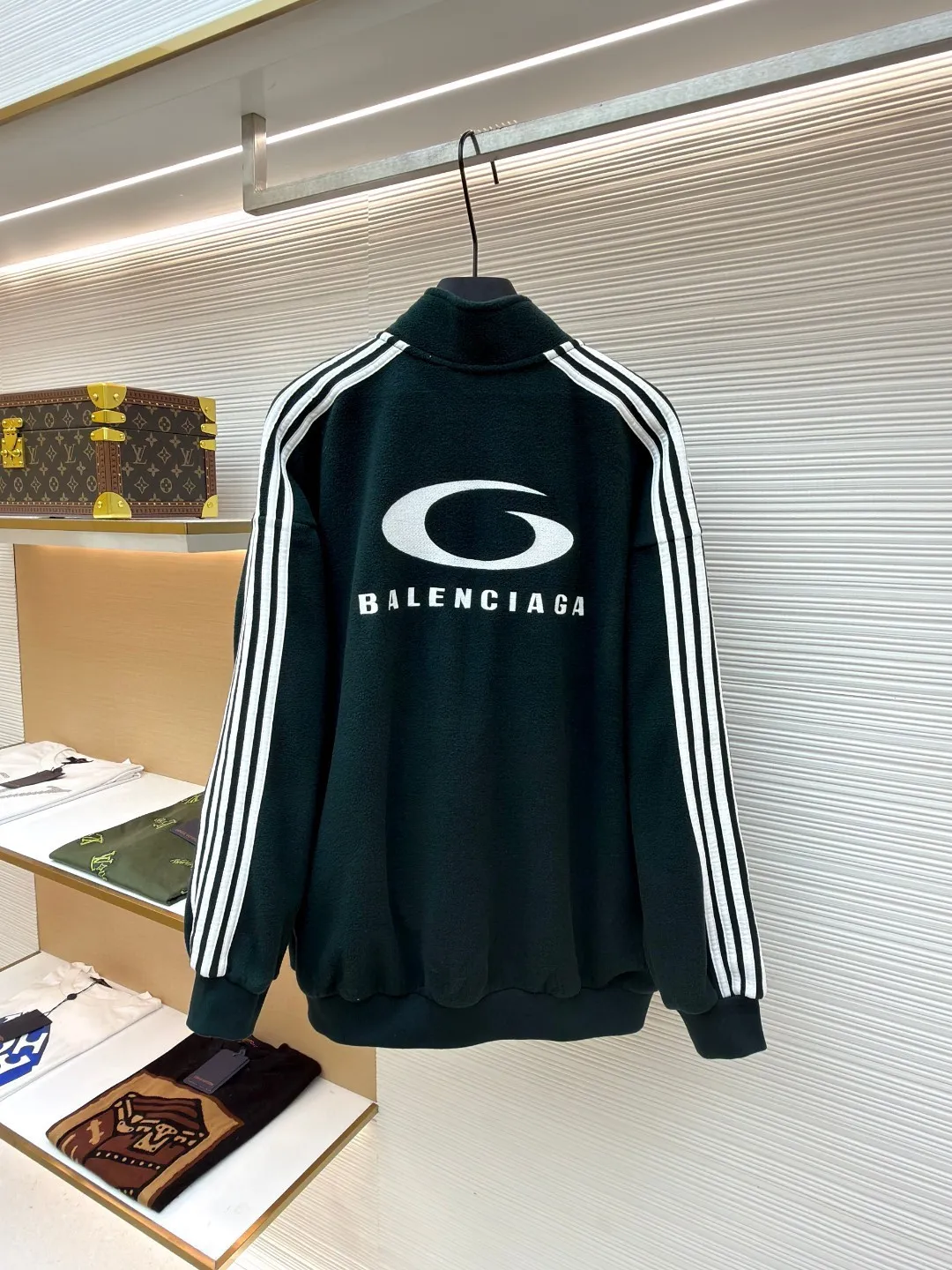 Balenciaga stand-up collar zipper jacket with embroidered sleeves ●Original version: Purchased and developed for 16500 ●Item number: 1680949-B25 ●Fabric: polar fleece fabric ●Technology: knitted production ●Version: Loose fit ●Weight: about 735 grams ●Size: XS-S-M-L ●Description: High-performance polar fleece knitted fabric is known for its excellent warmth retention and light texture. Through a special brushing process, a dense and rich velvet structure is formed on the surface of the fabric, which effectively locks in still air and achieves efficient heat insulation. The warmth retention per unit weight is better than that of traditional knitted materials. At the same time, its fiber gaps ensure that moisture can be exported in time, taking into account breathability. The fabric is usually treated with anti-static and water-repellent treatments to enhance practical functions, and has excellent ductility and anti-pilling properties. It feels soft and fluffy, and does not feel restrictive when moving. Using high-density stitching and multi-color embroidery thread, the pattern has clear edges and three-dimensional fullness; it is made with the overall tatami embroidery technology. To customize the embroidery thread material according to the pattern and color, you need to choose a suitable rice mat as the base material for embroidery to ensure that its surface is flat, smooth and suitable for embroidery. Draw line outlines on the fabric according to the embroidery pattern so that the outline can be accurately followed during embroidery. The contrasting piping on the sleeves is precisely stitched with hemming technology to strengthen the contour lines and improve wear resistance; the solid color fabric and white contrasting design enhance the visual impact. The gathered cuffs and waist are made of high-elastic rib material to enhance the fit and prevent the intrusion of cold wind. It is equipped with a double-ended zipper to achieve flexible opening and closing. The two zippered diagonal pockets take into account storage security and smooth styling, reflecting practical details. The silhouette is both unisex and unisex, with a gathered waist and straight body that balances looseness and slim fit. The high collar design extends the neck protection, echoing the theme of sports protection; the overall minimalist outline highlights the visual focus of embroidery and piping, transforming functional details into design elements, perfectly integrating sports genes and street art style. The overall wiring is straight and delicate, the fabric is comfortable and soft, and the color is consistent without color difference. It can be matched with the same style to create a fashionable look and control various occasions. Customized accessories, complete with three standards, same style for men and women!