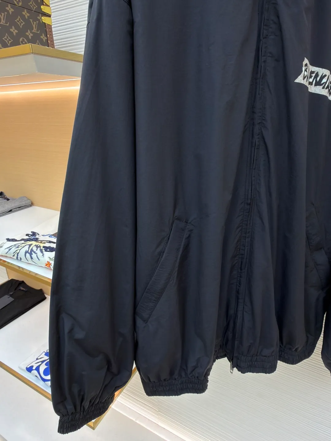 Balenciaga glue print jacket ●Original version: Purchased and developed for 20000 ●Item number: 1682403-B40 ●Fabric: woven nylon fabric ●Technology: glue printing production ●Color: black ●Version: fitted version ●Weight: about 480 grams ●Size: XS-S-M ●Description: This Balenciaga cotton blended jacket is made of 65% cotton and 35% polyester fiber blended fabric. It is first processed by a high-temperature pre-shrinking process to control the fabric shrinkage within 1% to avoid deformation after wearing and washing. The brand logo on the front of the body is made using glue printing technology. Before printing, the fabric is statically eliminated, and then the glue is tightly combined with the fabric through 150℃ high temperature printing. The pattern is clear, does not fall off and is friction-resistant. The jacket adopts a stand-up collar zipper design. The metal zipper has been treated with anti-oxidation plating and is smooth and easy to pull. The cuffs and hem are made of elastic ribbing. The rib weaving method is 1*1 double-needle technology, which is durable and not easy to loosen. The side seam pockets use invisible inlay technology with a stitch density of 8 stitches per centimeter. The shoulders are seamlessly taped. The overall craftsmanship takes into account the brand's iconic simple design and durability, and the details highlight the production standards of high-end clothing. The overall wiring is straight and delicate, the fabric is comfortable and soft, and the color is consistent without color difference. It can be matched with the same style to create a fashionable look and control various occasions. Customized accessories, complete with three standards, same style for men and women!