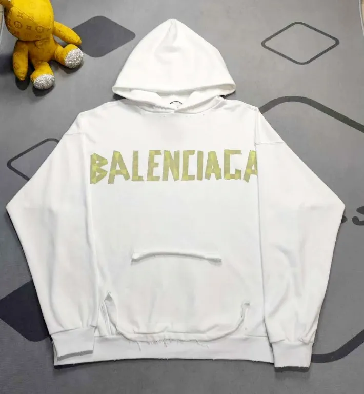 The top proven version of Balenciaga 23SS masking paper printed letters double-sided logo hooded loose hooded sweatshirt. This hoodie has a very interesting and cute design. The kangaroo pocket on the front of the large body is reverse-cut design. The double side pockets are hollow, which means that when viewed from the front, it actually deceives your vision. The real pockets are sewn on the reverse terry bottom. It is time-consuming and labor-intensive, but it is the core theme of the entire hoodie that cannot be ignored. The same detail is that the double side pockets are hemmed and stitched. And processed with holes; 480g heavy-weight pure cotton fabric with fine small terry bottom. After heavy mud dyeing and washing, the fabric still has a thick foundation and is comfortable and soft. The front and back double-sided textured paper transfer LOGO, and the front and back printing colors are different. The loose and large drop shoulder design is unisex. This style is also very suitable for girls to match. It is easy to create a lazy and casual street feel of the United States and France. Many holes are processed by hand grinding wheels on the body. Traces of muddying can be seen on the neckline, shoulder line, and side cuff splicing, but the visual effect transition is natural and soft without any sense of dirt. The old effect of the entire hoodie is excellent. The cuff threads are custom-woven in color; the packaging is washed and customized. The new gray silver letter main logo. The dropped shoulder model does not include shoulder width. The version is Kanye’s American style. Short and wide street casual version. From short sleeves to sweaters, this style is definitely not to be missed. Color: mud-dyed custom-woven navy Size: XS-S-M (Can be worn by both men and women, OS is loose and dropped on the shoulders) P:510