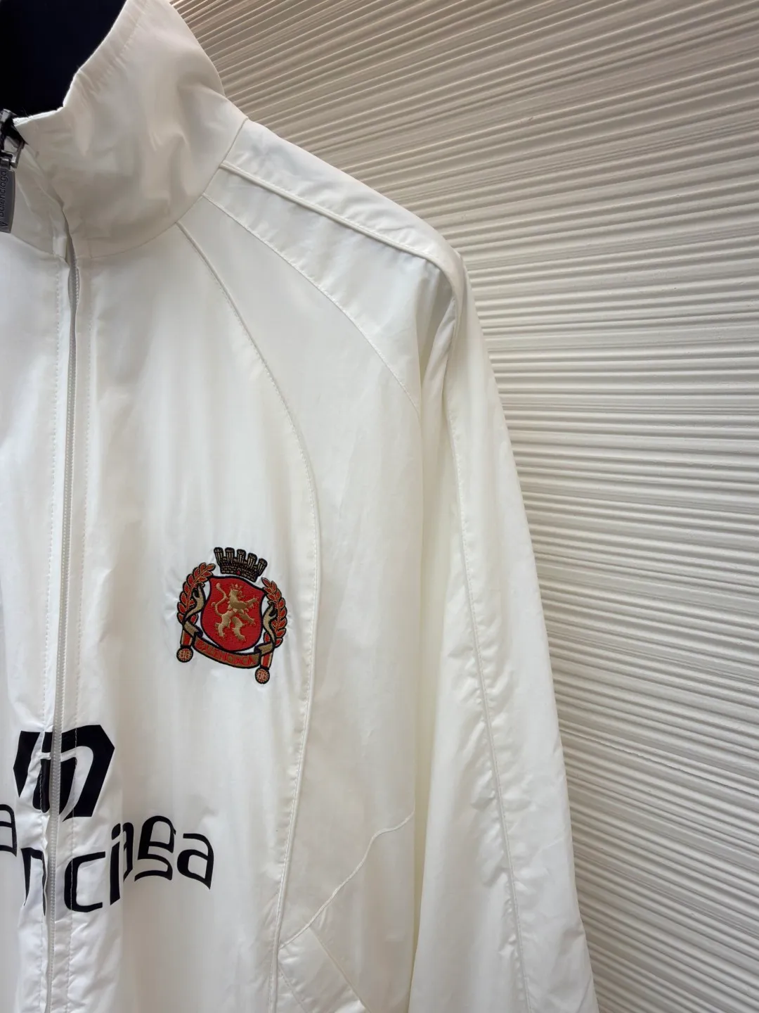 Balenciaga Manchester United co-branded No. 10 football jacket ●Authentic product: purchased and developed by 17260 ●Item number: 1680809-C65 ●Fabric: nylon fabric ●Technology: Printing ●Version: loose fit ●Size: 44-46-48-50 ●Description: Made of high-count and high-density nylon-cotton blended fabric. The lining is made of 32s combed cotton plain weave. The weight is 160g. It is embroidered by Tajima embroidery machine imported from Japan. The front panel + left and right sleeves are made of nylon material matte embroidery thread. The front and rear panels are made of DTF white ink heat transfer film material. The Y-plate pattern is scanned to make the pattern, and the material is cut by laser burning. The cut pieces are manually swept and positioned, and the front and back are hot-pressed with a high-temperature press machine to form. The letter composition on the front restores the flower effect, and the front and center are equipped with upper and lower rubber-threaded open-end zippers. Same style for men and women!