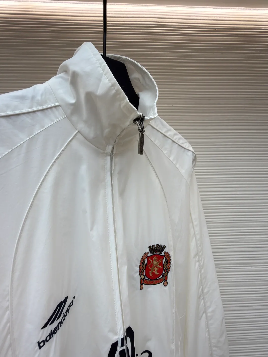 Balenciaga Manchester United co-branded No. 10 football jacket ●Authentic product: purchased and developed by 17260 ●Item number: 1680809-C65 ●Fabric: nylon fabric ●Technology: Printing ●Version: loose fit ●Size: 44-46-48-50 ●Description: Made of high-count and high-density nylon-cotton blended fabric. The lining is made of 32s combed cotton plain weave. The weight is 160g. It is embroidered by Tajima embroidery machine imported from Japan. The front panel + left and right sleeves are made of nylon material matte embroidery thread. The front and rear panels are made of DTF white ink heat transfer film material. The Y-plate pattern is scanned to make the pattern, and the material is cut by laser burning. The cut pieces are manually swept and positioned, and the front and back are hot-pressed with a high-temperature press machine to form. The letter composition on the front restores the flower effect, and the front and center are equipped with upper and lower rubber-threaded open-end zippers. Same style for men and women!