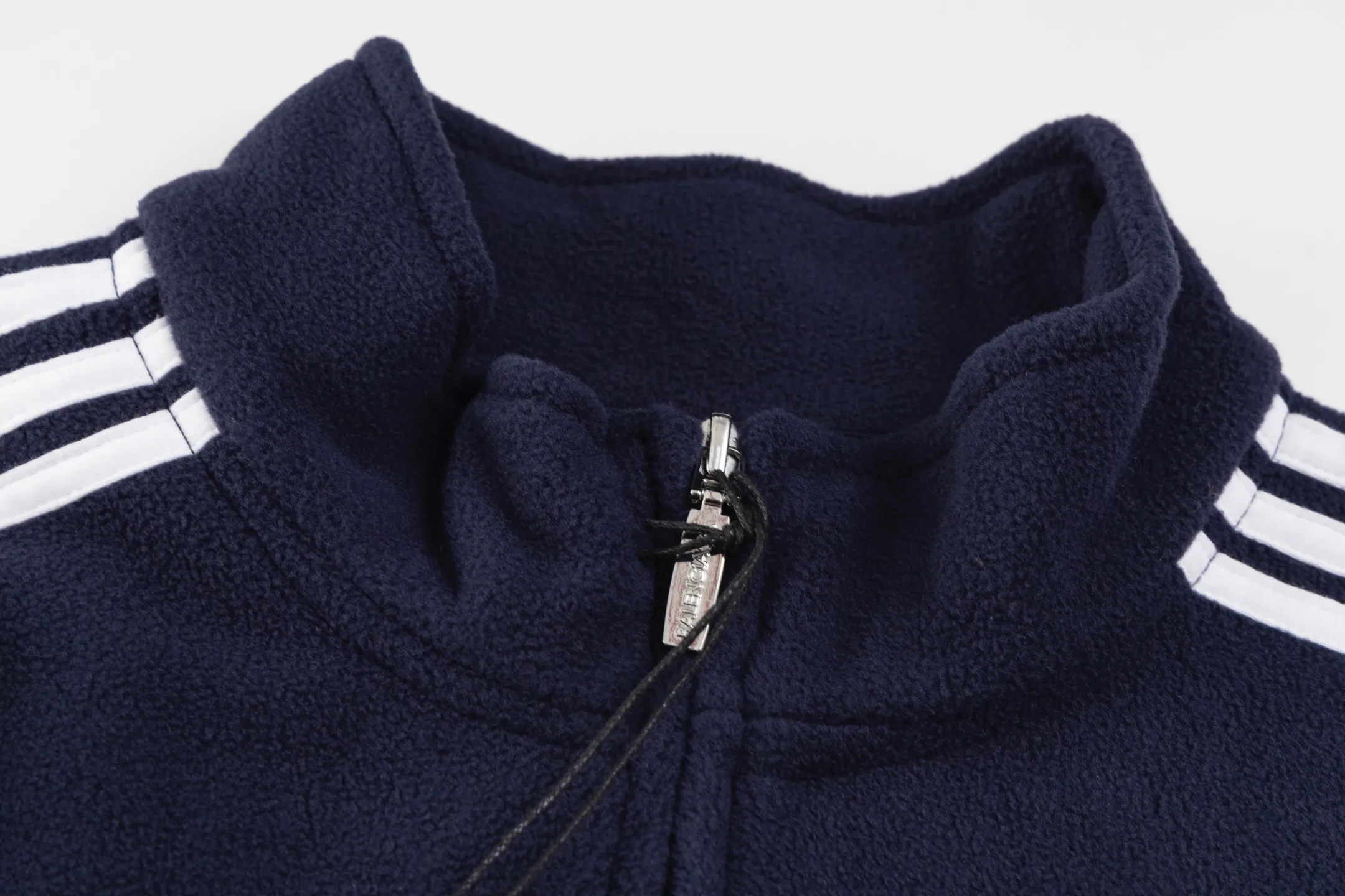🅿️500 [Exclusive supply] BLCG ring embroidered polar fleece jacket. The fabric is made of polyester filament and passed through a circular knitting machine. The warp and weft yarns are woven into each other into a double-sided knitted structure. The front and back are flat loops. The polar fleece fabric is formed after a series of processes such as dyeing, raising, carding, shearing, and polarization. The suede texture is soft and the fiber characteristics make it almost non-absorbent. It can quickly drain sweat to the outer layer of the fabric and evaporate quickly, maintaining good breathability. The suede surface can lock the air and form a stagnant air layer around the body, effectively preventing heat loss and providing good warmth retention properties. The imported embroidery machine uses 3000 needles + 11000 needles to form a small and large loop sports icon embroidery on the front and back panels. The double-axis linear guide drives the embroidery frame, and the frame moving accuracy can reach 0.01mm/P, ensuring precise positioning of the embroidery pattern. The trim is precisely positioned along the specified contour from the cuffs to the shoulder collar seam to ensure symmetry and overall smoothness. Before actual sewing, use very fine basting stitches for pre-fixing. This step is crucial to prevent the trim from slipping, twisting, or wrinkling during the sewing process and ensuring that the final stitch is straight and perfect. Size:S/M/L/XL