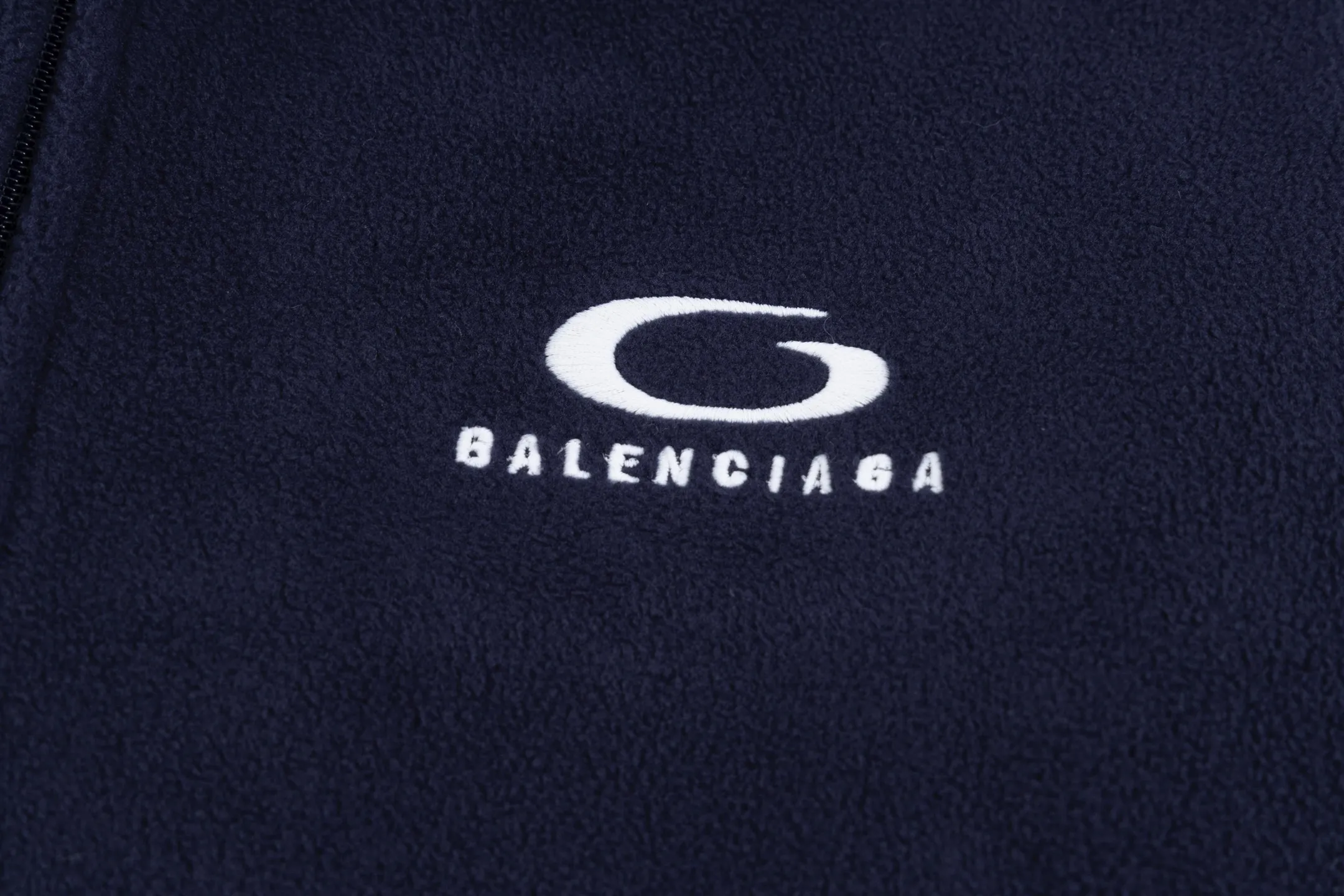 🅿️500 [Exclusive supply] BLCG ring embroidered polar fleece jacket. The fabric is made of polyester filament and passed through a circular knitting machine. The warp and weft yarns are woven into each other into a double-sided knitted structure. The front and back are flat loops. The polar fleece fabric is formed after a series of processes such as dyeing, raising, carding, shearing, and polarization. The suede texture is soft and the fiber characteristics make it almost non-absorbent. It can quickly drain sweat to the outer layer of the fabric and evaporate quickly, maintaining good breathability. The suede surface can lock the air and form a stagnant air layer around the body, effectively preventing heat loss and providing good warmth retention properties. The imported embroidery machine uses 3000 needles + 11000 needles to form a small and large loop sports icon embroidery on the front and back panels. The double-axis linear guide drives the embroidery frame, and the frame moving accuracy can reach 0.01mm/P, ensuring precise positioning of the embroidery pattern. The trim is precisely positioned along the specified contour from the cuffs to the shoulder collar seam to ensure symmetry and overall smoothness. Before actual sewing, use very fine basting stitches for pre-fixing. This step is crucial to prevent the trim from slipping, twisting, or wrinkling during the sewing process and ensuring that the final stitch is straight and perfect. Size:S/M/L/XL