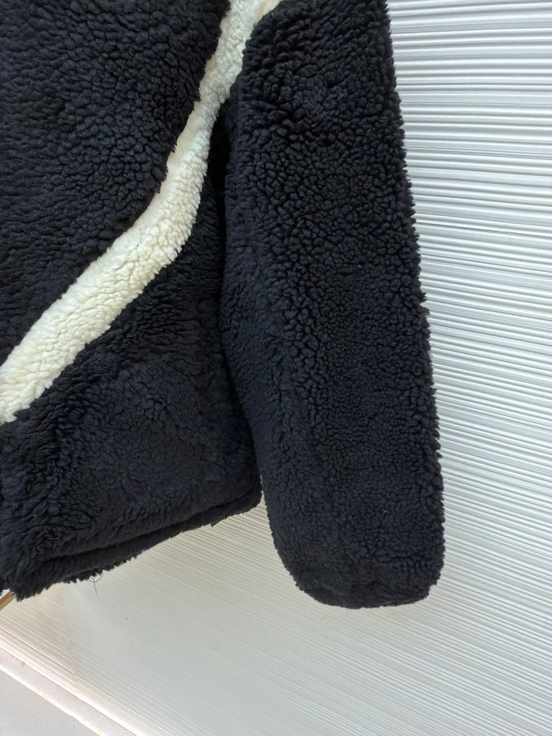 Balenciaga ski series sherpa stand collar jacket ●Original version: purchased and developed by 14616 ●Item number: 1681957-B50 ●Fabric: sherpa fabric ●Technology: made on positioning cutting machine ●Color: black and white ●Version: fitted version ●Weight: about 1190 grams ●Size: XXS-XS-S-M ●Description: Made of high-density imitation lamb wool fabric, the black/white two-color terry is pre-shrunk, making the velvet feel fluffy and not easy to shed. The core pattern of the body is a three-dimensional splicing process: the white terry pieces are precisely cut by laser, and the edges are sewn by hand stitching to form a smooth curve layer with the black base, and the error is controlled within 0.2cm. The chest logo uses a combination of flocking embossing and offset printing, and the brand words and patterns have both a three-dimensional feel and wear resistance. The placket is equipped with a hidden metal zipper, and the chain teeth are matte black-plated, making it smooth and visually low-key. The cuffs and hem are ribbed with the same fabric, and the elastic rebound rate is ≥90%. The inner lining is lined with light polyester fiber interlining to improve the comfort of putting on and taking off. The overall stitching is made of high-tenacity nylon thread. The even stitch length of 9 needles per centimeter takes into account both warmth retention and style. The overall wiring is straight and delicate, the fabric is comfortable and soft, and the color is consistent without color difference. It can be matched with the same style to create a fashionable look and control various occasions. Customized accessories, complete with three standards, same style for men and women!