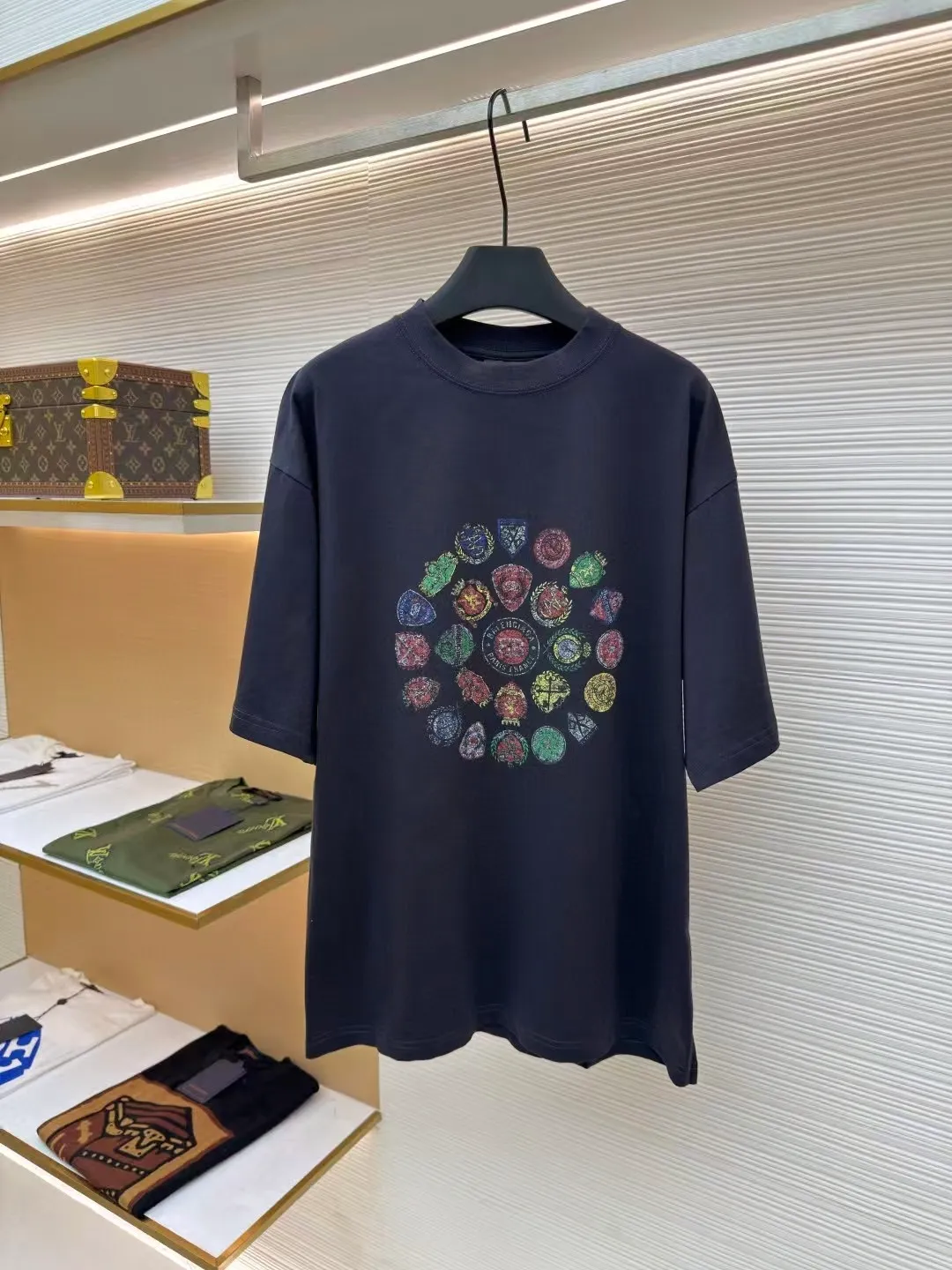 Balenciaga collection of trademark printed round neck short sleeves ●Original version: Purchased and developed by 3795 ●Item number: 1680780-A10 ●Fabric: Retro jersey fabric ●Technology: Glue printing ●Version: Loose version ●Weight: about 235 grams ●Size: Thread, 270g. 24S fabric is a medium-to-thick yarn, suitable for creating thick, crisp fabrics with a slightly rough texture, which is in line with the "natural and original" effect pursued by retro style. The texture is soft, breathable and elastic, suitable for close-fitting wear and able to create a simple and smooth silhouette. The loose silhouette design details with a retro feel are reflected through old textures, faded processing, and classic tailoring. Dark floral dot multi-layer overlay printing is an advanced printing technology that combines fine patterns and three-dimensional layers. Its core is to use high-mesh dot plate making to overprint transparent or light-colored printing paste on the fabric base multiple times with micron-level precision. Each overlay is accurately aligned to form a faint dark flower texture. The printing pattern does not rely on bright colors, but creates subtle light and shadow gradients and tactile layering on the surface of the fabric through the thickness difference of slurry accumulation and light refraction. The pattern shows subtle changes at different angles, combining visual depth and long-lasting washability. Oversize loose silhouette design, basic round neckline, dropped shoulder line, vertical pit woven code from top to bottom, collar, cuffs, and hem all have ruffles, and the sleeve length is longer to highlight the details. The thickness of the ready-made garment is the same as the original version, and it is additionally shaped to make the upper body wider and not easily deformed. The overall wiring is straight and delicate, the fabric is comfortable and soft, and the color is consistent without color difference. It can be matched with the same style to create a fashionable look and control various occasions. Customized accessories, complete with three standards, same style for men and women!