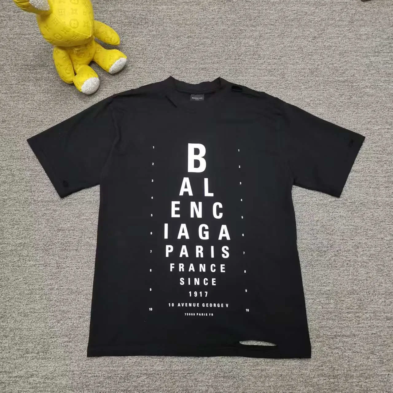 Top version Balenciaga letter eye chart short sleeves 2024SS new main wheat upper body. Printing uses imported elliptical machine glue printing to distinguish the market heat transfer process. Threaded neckline. Sleeves and hems are frayed and cut. The front panel is scanned by computer for precise alignment and the color of the printing is completely restored. The fabric is made of 32s240g. The three standards for large quantities + code number stickers + dustproof paper with logo. Size: Xs-L. Color: black. P:280