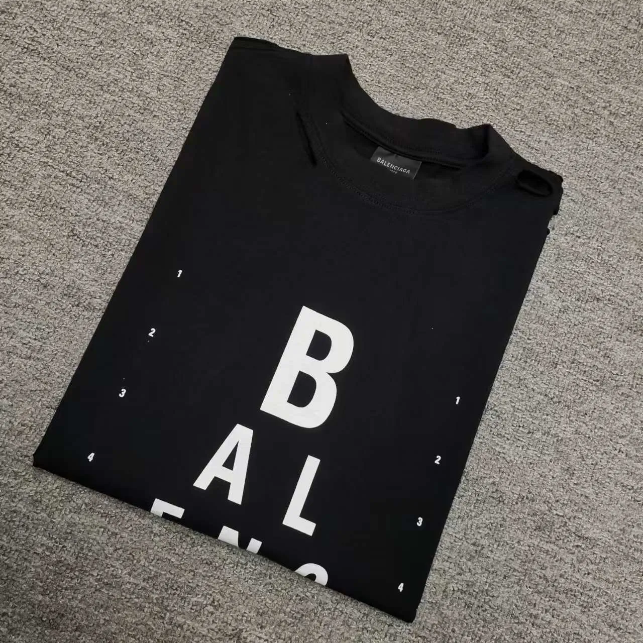 Top version Balenciaga letter eye chart short sleeves 2024SS new main wheat upper body. Printing uses imported elliptical machine glue printing to distinguish the market heat transfer process. Threaded neckline. Sleeves and hems are frayed and cut. The front panel is scanned by computer for precise alignment and the color of the printing is completely restored. The fabric is made of 32s240g. The three standards for large quantities + code number stickers + dustproof paper with logo. Size: Xs-L. Color: black. P:280