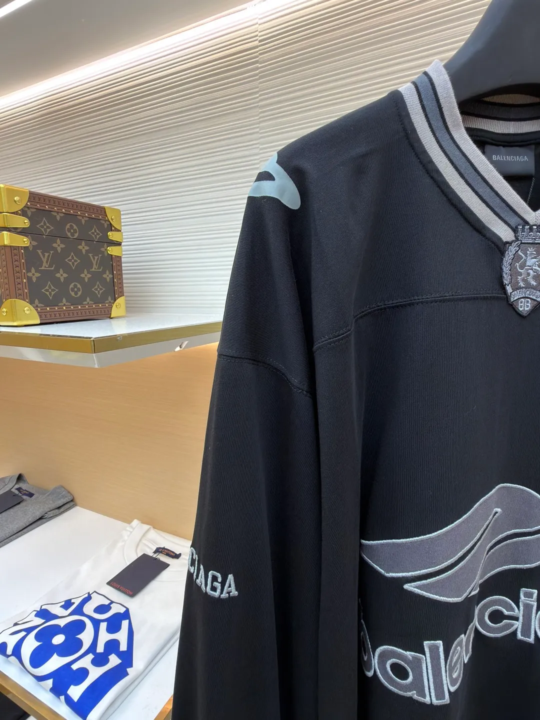 Balenciaga team series V-neck long sleeves ●Original version: purchased and developed by 8016 ●Item number: 1682073-A55 ●Fabric: plain knitted compact cotton fabric ●Technology: glue printing ●Color: black ●Version: loose version ●Weight: about 380 grams ●Size: XS-S-M-L ●Description: The main body is made of 24-count special woven compact cotton, with a weight of 185g/㎡. Compact spinning technology is applied in the spinning process, which significantly reduces yarn hairiness and makes the yarn smoother and stronger. This gives the fabric an unusually dense structure, a smooth and smooth surface, and excellent pilling resistance, while retaining the softness and breathability of pure cotton. The weight of 185g is light to middleweight, ensuring that the clothing is light, drapeable and can move freely. It is very suitable for creating a long-sleeved shirt that combines sportiness with daily comfort. The V-neck part is made of two different colors of high-elastic rib fabrics. The process step is to first weave ribbed belts of two colors separately, and then through precise cutting and splicing, form a V-shaped neckline with sharp color contrast. It breaks the monotony of the solid color body, uses strong color contrast to create a young and energetic visual focus, and optimizes the neck line. The pattern is pre-cut and formed into patches on fabrics of different materials or colors, and then covered on the body. Finally, high-density embroidery thread is used to fix the edges and outline the internal details. Its function is to create patterns with bright colors, strong texture contrast, three-dimensionality and durability. The edges of the pattern are strong and not easy to wear. A special elastic paste is screen-printed on the sleeves to create brightly colored patterns with a slightly coated feel. The elastic paste ensures that the printed area can stretch with the fabric without cracking. It forms a texture contrast between one flat and one convex with the three-dimensional sense of appliqué, which increases the interest and complexity of the design. The overall wiring is straight and delicate, the fabric is comfortable and soft, and the color is consistent without color difference. It can be matched with the same style to create a fashionable look and control various occasions. Customized accessories, complete with three standards, same style for men and women!