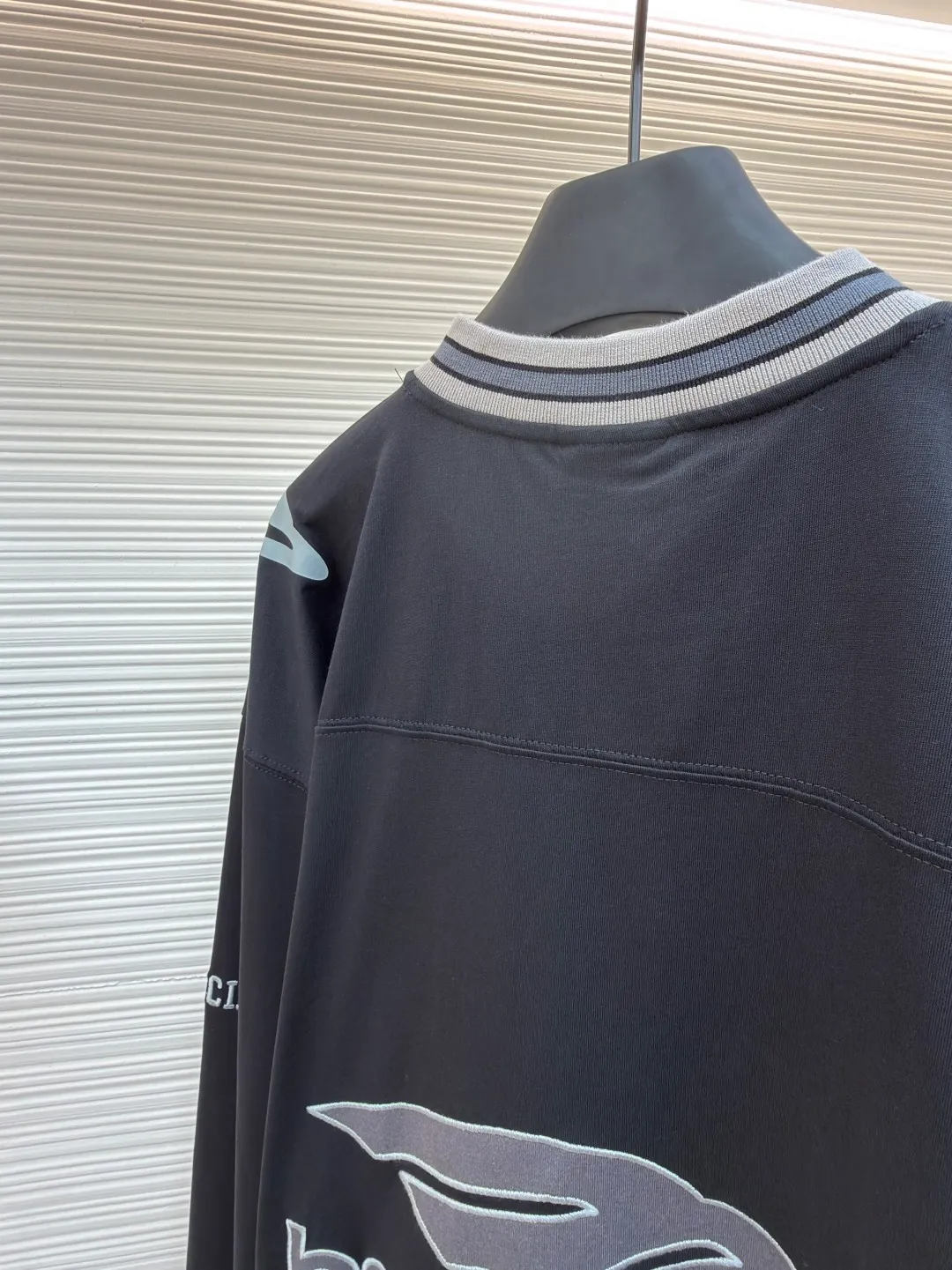 Balenciaga team series V-neck long sleeves ●Original version: purchased and developed by 8016 ●Item number: 1682073-A55 ●Fabric: plain knitted compact cotton fabric ●Technology: glue printing ●Color: black ●Version: loose version ●Weight: about 380 grams ●Size: XS-S-M-L ●Description: The main body is made of 24-count special woven compact cotton, with a weight of 185g/㎡. Compact spinning technology is applied in the spinning process, which significantly reduces yarn hairiness and makes the yarn smoother and stronger. This gives the fabric an unusually dense structure, a smooth and smooth surface, and excellent pilling resistance, while retaining the softness and breathability of pure cotton. The weight of 185g is light to middleweight, ensuring that the clothing is light, drapeable and can move freely. It is very suitable for creating a long-sleeved shirt that combines sportiness with daily comfort. The V-neck part is made of two different colors of high-elastic rib fabrics. The process step is to first weave ribbed belts of two colors separately, and then through precise cutting and splicing, form a V-shaped neckline with sharp color contrast. It breaks the monotony of the solid color body, uses strong color contrast to create a young and energetic visual focus, and optimizes the neck line. The pattern is pre-cut and formed into patches on fabrics of different materials or colors, and then covered on the body. Finally, high-density embroidery thread is used to fix the edges and outline the internal details. Its function is to create patterns with bright colors, strong texture contrast, three-dimensionality and durability. The edges of the pattern are strong and not easy to wear. A special elastic paste is screen-printed on the sleeves to create brightly colored patterns with a slightly coated feel. The elastic paste ensures that the printed area can stretch with the fabric without cracking. It forms a texture contrast between one flat and one convex with the three-dimensional sense of appliqué, which increases the interest and complexity of the design. The overall wiring is straight and delicate, the fabric is comfortable and soft, and the color is consistent without color difference. It can be matched with the same style to create a fashionable look and control various occasions. Customized accessories, complete with three standards, same style for men and women!