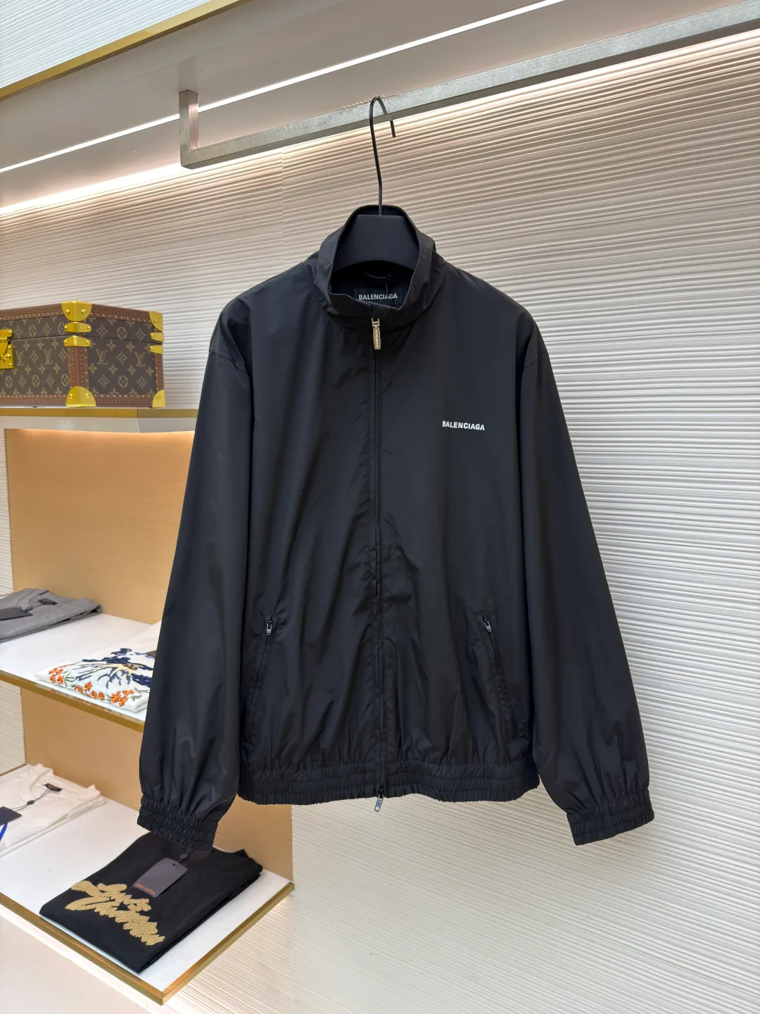 Balenciaga stand collar logo embroidered quick-drying jacket ●Original version: purchased and developed by 10128 ●Item number: 1681403-B40 ●Fabric: Satin blended fabric ●Technology: embroidery production ●Color: black ●Version: Loose fit ●Weight: about 380 grams ●Size: 36-38-40-42 ●Description: This jacket is made of high-quality windproof fabric, with a crisp texture and good breathability. The stand-up collar design fits the neck and is windproof and neat. The brand letters on the back adopt three-dimensional embroidery technology, the stitches are even and full, and the letter shape is three-dimensional and layered, making it highly recognizable. The body is cut in a loose fit with smooth and natural lines, making it comfortable and casual to wear. The ribbed design on the cuffs and hem has excellent elasticity, fits the body shape, and is windproof and warm. The zipper is smooth and durable, and harmonizes with the overall style. From fabric selection to embroidery craftsmanship to rib processing in details, every step reflects the brand's rigorous control of craftsmanship, not only showing a sense of street fashion, but also ensuring practicality and quality through exquisite craftsmanship. The overall wiring is straight and delicate, the fabric is comfortable and soft, and the color is consistent without color difference. It can be matched with the same style to create a fashionable look, and can be used in various occasions. Customized accessories, complete with three standards, the same style for men and women.