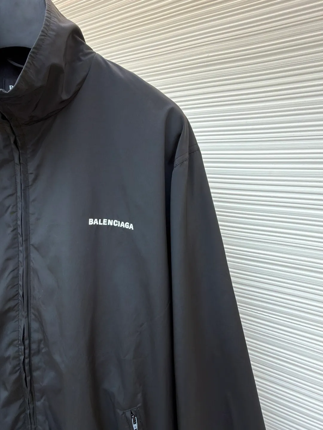 Balenciaga stand collar logo embroidered quick-drying jacket ●Original version: purchased and developed by 10128 ●Item number: 1681403-B40 ●Fabric: Satin blended fabric ●Technology: embroidery production ●Color: black ●Version: Loose fit ●Weight: about 380 grams ●Size: 36-38-40-42 ●Description: This jacket is made of high-quality windproof fabric, with a crisp texture and good breathability. The stand-up collar design fits the neck and is windproof and neat. The brand letters on the back adopt three-dimensional embroidery technology, the stitches are even and full, and the letter shape is three-dimensional and layered, making it highly recognizable. The body is cut in a loose fit with smooth and natural lines, making it comfortable and casual to wear. The ribbed design on the cuffs and hem has excellent elasticity, fits the body shape, and is windproof and warm. The zipper is smooth and durable, and harmonizes with the overall style. From fabric selection to embroidery craftsmanship to rib processing in details, every step reflects the brand's rigorous control of craftsmanship, not only showing a sense of street fashion, but also ensuring practicality and quality through exquisite craftsmanship. The overall wiring is straight and delicate, the fabric is comfortable and soft, and the color is consistent without color difference. It can be matched with the same style to create a fashionable look, and can be used in various occasions. Customized accessories, complete with three standards, the same style for men and women.