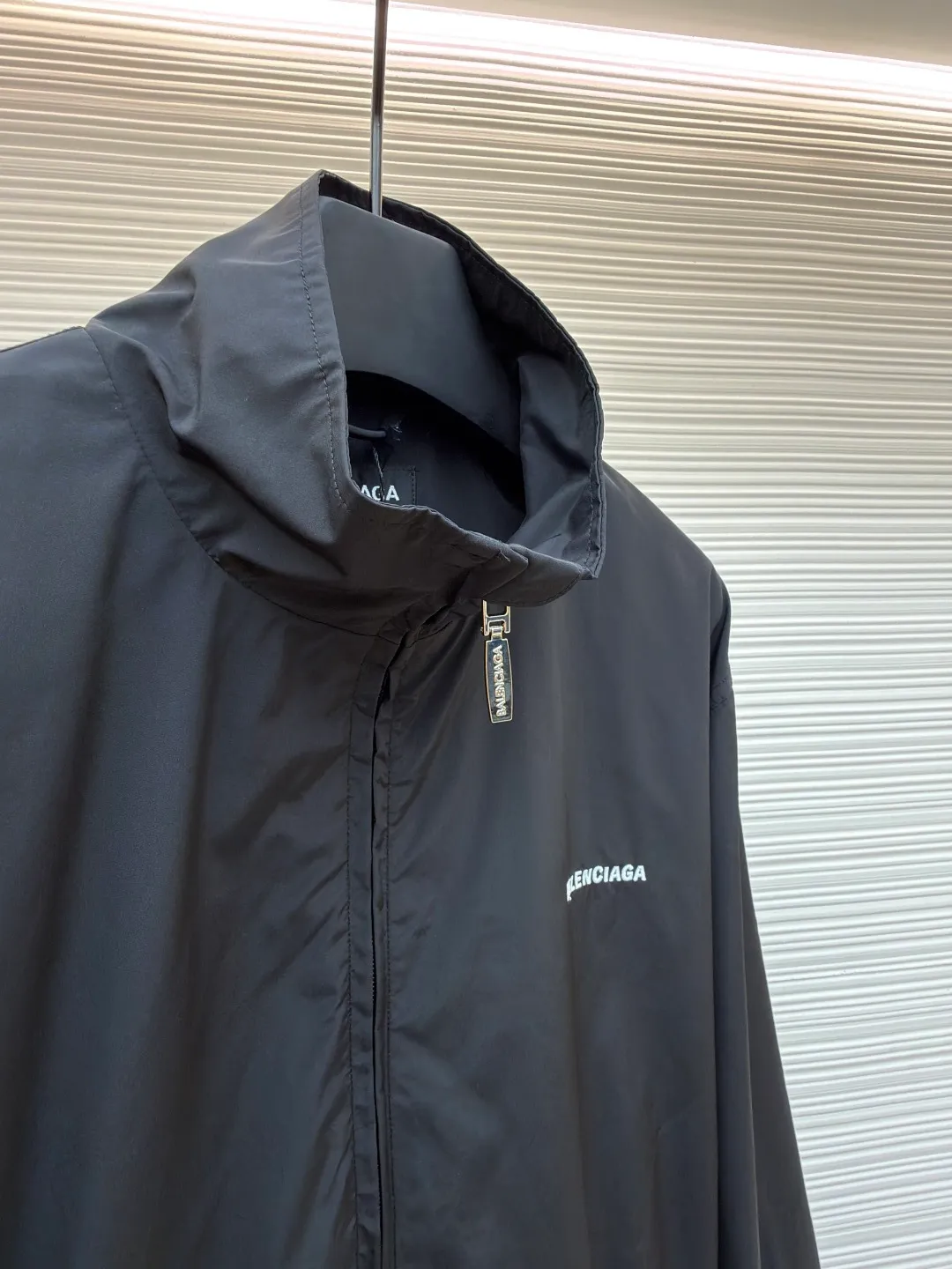 Balenciaga stand collar logo embroidered quick-drying jacket ●Original version: purchased and developed by 10128 ●Item number: 1681403-B40 ●Fabric: Satin blended fabric ●Technology: embroidery production ●Color: black ●Version: Loose fit ●Weight: about 380 grams ●Size: 36-38-40-42 ●Description: This jacket is made of high-quality windproof fabric, with a crisp texture and good breathability. The stand-up collar design fits the neck and is windproof and neat. The brand letters on the back adopt three-dimensional embroidery technology, the stitches are even and full, and the letter shape is three-dimensional and layered, making it highly recognizable. The body is cut in a loose fit with smooth and natural lines, making it comfortable and casual to wear. The ribbed design on the cuffs and hem has excellent elasticity, fits the body shape, and is windproof and warm. The zipper is smooth and durable, and harmonizes with the overall style. From fabric selection to embroidery craftsmanship to rib processing in details, every step reflects the brand's rigorous control of craftsmanship, not only showing a sense of street fashion, but also ensuring practicality and quality through exquisite craftsmanship. The overall wiring is straight and delicate, the fabric is comfortable and soft, and the color is consistent without color difference. It can be matched with the same style to create a fashionable look, and can be used in various occasions. Customized accessories, complete with three standards, the same style for men and women.