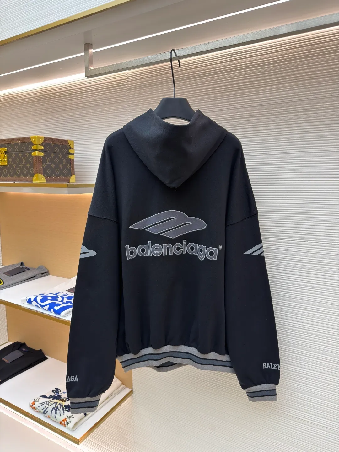 Balenciaga 3B football Polo hoodie ●Original version: Purchased and developed for 9999 ●Item number: 1681997-B40 ●Fabric: cotton fabric ●Technology: embroidery applique production ●Color: black ●Version: loose fit ●Weight: about 860 grams ●Size: XS-S-M-L ●Description: The neckline adopts a half-open button design and is decorated with metal badges to enhance the layered look; the main body of the garment presents the brand logo through three-dimensional foam printing technology, and the grayscale gradient effect enhances the visual texture. The cuffs and hem are edged with contrasting ribbing, which has moderate elasticity and is not easily deformed; a collage label is embedded in the left hem, and the details echo the brand's street style. The partial logo embroidery on the shoulders and cuffs echoes the main pattern. The overall craftsmanship takes into account practical wearability and brand recognition, making it suitable for daily casual or trendy looks. The overall wiring is straight and delicate, the fabric is comfortable and soft, and the color is consistent without color difference. It can be matched with the same style to create a fashionable look and control various occasions. Customized accessories, complete with three standards, same style for men and women!