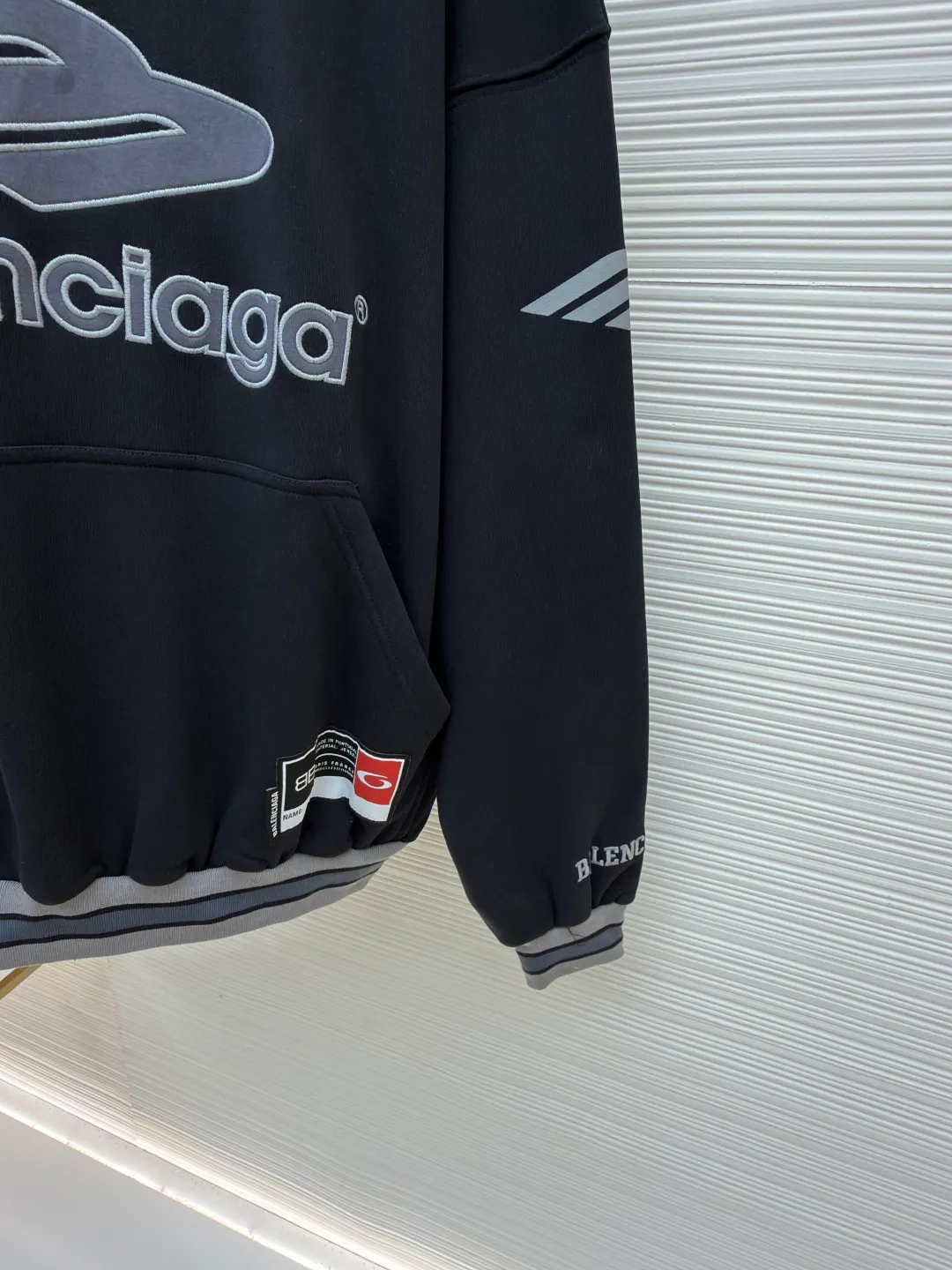 Balenciaga 3B football Polo hoodie ●Original version: Purchased and developed for 9999 ●Item number: 1681997-B40 ●Fabric: cotton fabric ●Technology: embroidery applique production ●Color: black ●Version: loose fit ●Weight: about 860 grams ●Size: XS-S-M-L ●Description: The neckline adopts a half-open button design and is decorated with metal badges to enhance the layered look; the main body of the garment presents the brand logo through three-dimensional foam printing technology, and the grayscale gradient effect enhances the visual texture. The cuffs and hem are edged with contrasting ribbing, which has moderate elasticity and is not easily deformed; a collage label is embedded in the left hem, and the details echo the brand's street style. The partial logo embroidery on the shoulders and cuffs echoes the main pattern. The overall craftsmanship takes into account practical wearability and brand recognition, making it suitable for daily casual or trendy looks. The overall wiring is straight and delicate, the fabric is comfortable and soft, and the color is consistent without color difference. It can be matched with the same style to create a fashionable look and control various occasions. Customized accessories, complete with three standards, same style for men and women!