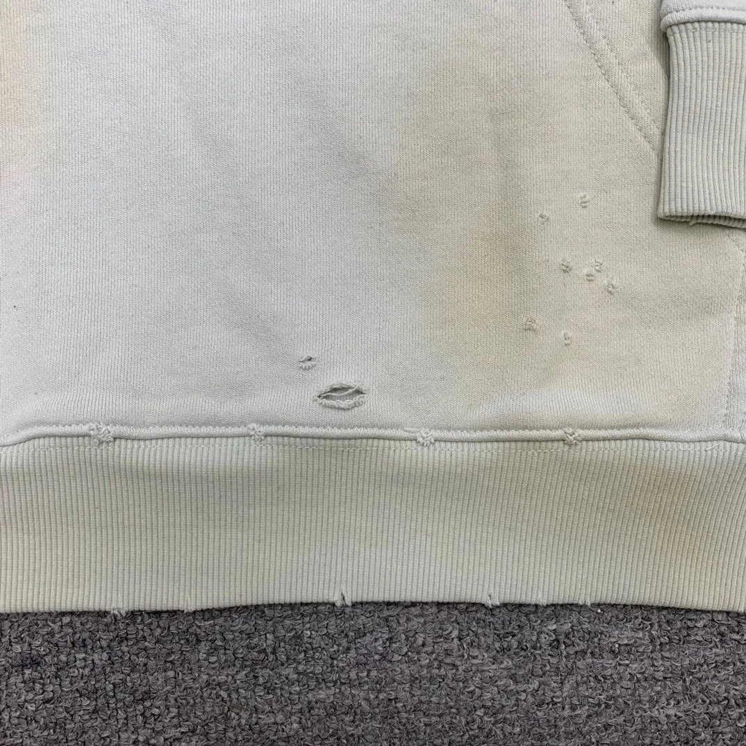Additional details————Top-level verified version 23FW BALENCIAGA Paris Manchester United limited edition distressed male and female couple star same style pure cotton loose hooded sweatshirt [very suitable for Douyin, and other platforms! The letters in the LOGO position have been damaged and polished! 】 The fabric is custom-made washed knitted cotton terry material. The upper body is very soft. The front panel uses a classic hand pocket with a worn effect. The overall yellow and dirty effect is all artificially sprayed with majolica. It requires proficiency and experience to achieve this natural and elegant effect!  Customized towel embroidery on the chest, heavily damaged! The aging effect is very obvious! The overall artificial positioning coating is hand-made, washed and dirty. The frayed hole craftsmanship has a hand-painted graffiti effect. The arms behind the bend are made of open-stitch frayed craftsmanship. The wiring is delicate. Elastic cuff design. The whole body is hand-positioned with muddy dyeing and frayed effect! Ready-made garments are washed twice with water +➕ once with wax. It feels smooth!   The Manchester United letters and logo on the chest are designed with full embroidery and the details are visible!  Size: XS-L Color: White Black P: 470