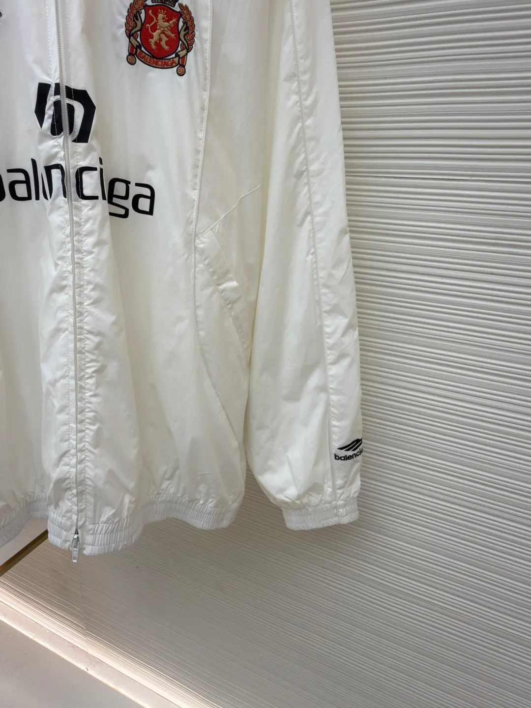 Balenciaga Manchester United co-branded No. 10 football jacket ●Authentic product: purchased and developed by 17260 ●Item number: 1680809-C65 ●Fabric: nylon fabric ●Technology: Printing ●Version: loose fit ●Size: 44-46-48-50 ●Description: Made of high-count and high-density nylon-cotton blended fabric. The lining is made of 32s combed cotton plain weave. The weight is 160g. It is embroidered by Tajima embroidery machine imported from Japan. The front panel + left and right sleeves are made of nylon material matte embroidery thread. The front and rear panels are made of DTF white ink heat transfer film material. The Y-plate pattern is scanned to make the pattern, and the material is cut by laser burning. The cut pieces are manually swept and positioned, and the front and back are hot-pressed with a high-temperature press machine to form. The letter composition on the front restores the flower effect, and the front and center are equipped with upper and lower rubber-threaded open-end zippers. Same style for men and women!