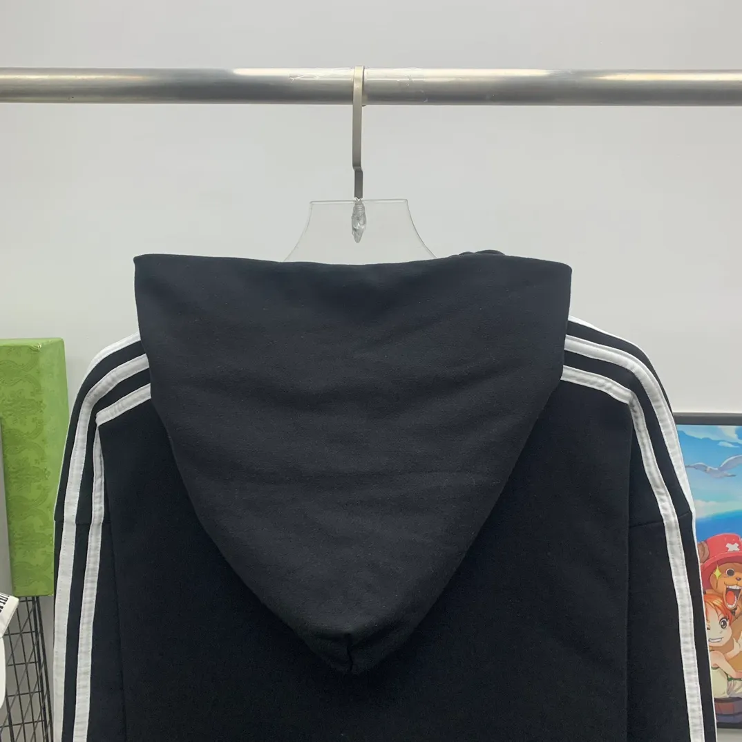 The top tested version of BALENCIAGA/Paris co-branded Adidas three-leaf clover LOGO embroidered hooded sweatshirt. The fabric is made of Paris ZP custom-woven and dyed cotton terry fabric. Weighing 450 grams, the cloth surface is clean. The cloth pattern is clear, soft and comfortable. The threads are dyed with no color difference. The classic pattern embroidery uses imported embroidery, and the letters are clear, three-dimensional and without rough edges. Custom-woven two-way zipper hardware, the upper zipper is BALENCIAGA, the lower zipper is Adidas, with electroplating effect! The sense of high-end is straight away! Comparisons welcome. The version adopts OS loose shoulder design. Same style for men and women. Color: Black Size: XS-L P:410