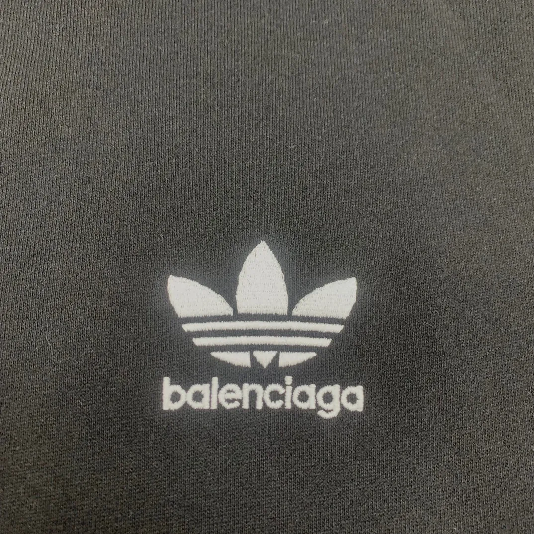 The top tested version of BALENCIAGA/Paris co-branded Adidas three-leaf clover LOGO embroidered hooded sweatshirt. The fabric is made of Paris ZP custom-woven and dyed cotton terry fabric. Weighing 450 grams, the cloth surface is clean. The cloth pattern is clear, soft and comfortable. The threads are dyed with no color difference. The classic pattern embroidery uses imported embroidery, and the letters are clear, three-dimensional and without rough edges. Custom-woven two-way zipper hardware, the upper zipper is BALENCIAGA, the lower zipper is Adidas, with electroplating effect! The sense of high-end is straight away! Comparisons welcome. The version adopts OS loose shoulder design. Same style for men and women. Color: Black Size: XS-L P:410