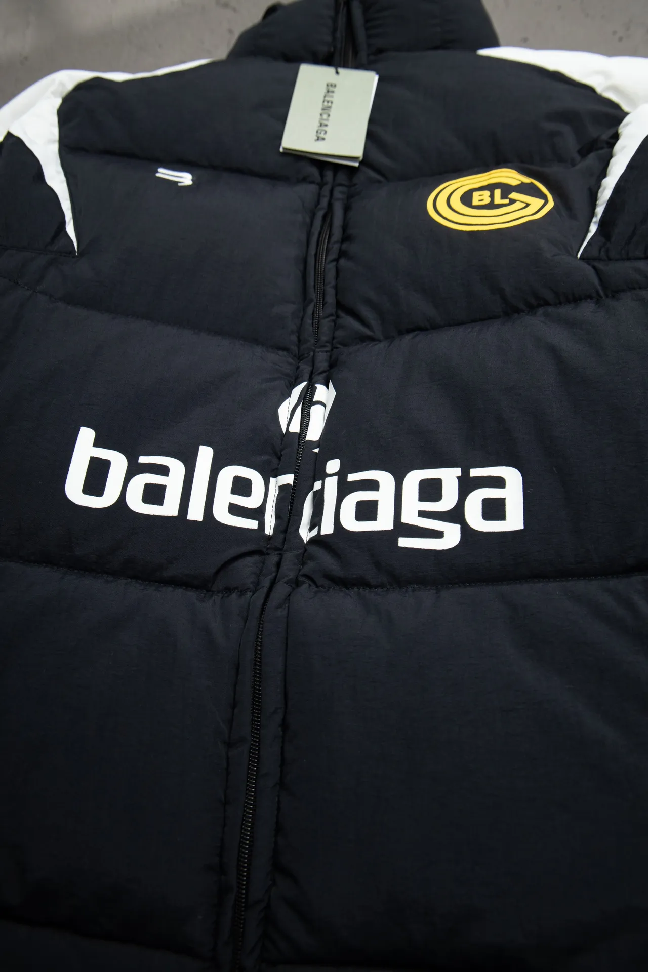 💰760 [Highest version, differentiated currency] Balenciaga / Balenciaga Blcg 24SS Manchester United football No. 10 black and white stitching joint stitching training down jacket, official website synchronized. The surface fabric and lining are made of customized high-density cloud-feel nylon fabric. The fabric has a level 4 water-repellent coating process. The lining is made of double-layer 330 gallbladder. Filled with 600 grams of Xinjiang pearl particle cotton. Extremely full!  The fabrics are the same as the original. Double-layer materials are used. The whole dress is full of style. Professional pattern makers from the original big-name OEM factory make patterns. Laser three-dimensional cutting. Because there are many splicing places, ordinary pattern makers are difficult to handle. Good products are made with care. Good goods take a long time. The whole body embroidery is operated by professional embroidery machines imported from island countries to make the embroidery details reach the top level. The whole body printing parts are operated using imported environmentally friendly offset printing technology. The printing is firm. The whole clothing accessories are molded and customized with hardware zippers and air holes. Double-hole limit buckle All have the same LOGO as the original version. Customized and washed as the original version. Main mark. Brand zipper seal bag. Brand LOGO moisture-proof paper. 3D laser cutting. Double-layer material. 5 meters of cloth for the whole piece. Extremely high cost. Composed of 47 pieces. Very slow production. Zipper pockets on both sides. Elastic cuff design. Imported environmentally friendly glue thermoset ink printing technology. Tajima high-speed embroidery machine embroidery Sporty B. Three-dimensional and full. The cuffs are equipped with new custom football embroidery patches. Customized hardware zippers. Double slider design. Customized original air holes. Customized original logo double-hole limit buckles. Original main mark and washed tag. Brand packaging. Color: black. Size: 46/48/50/52.