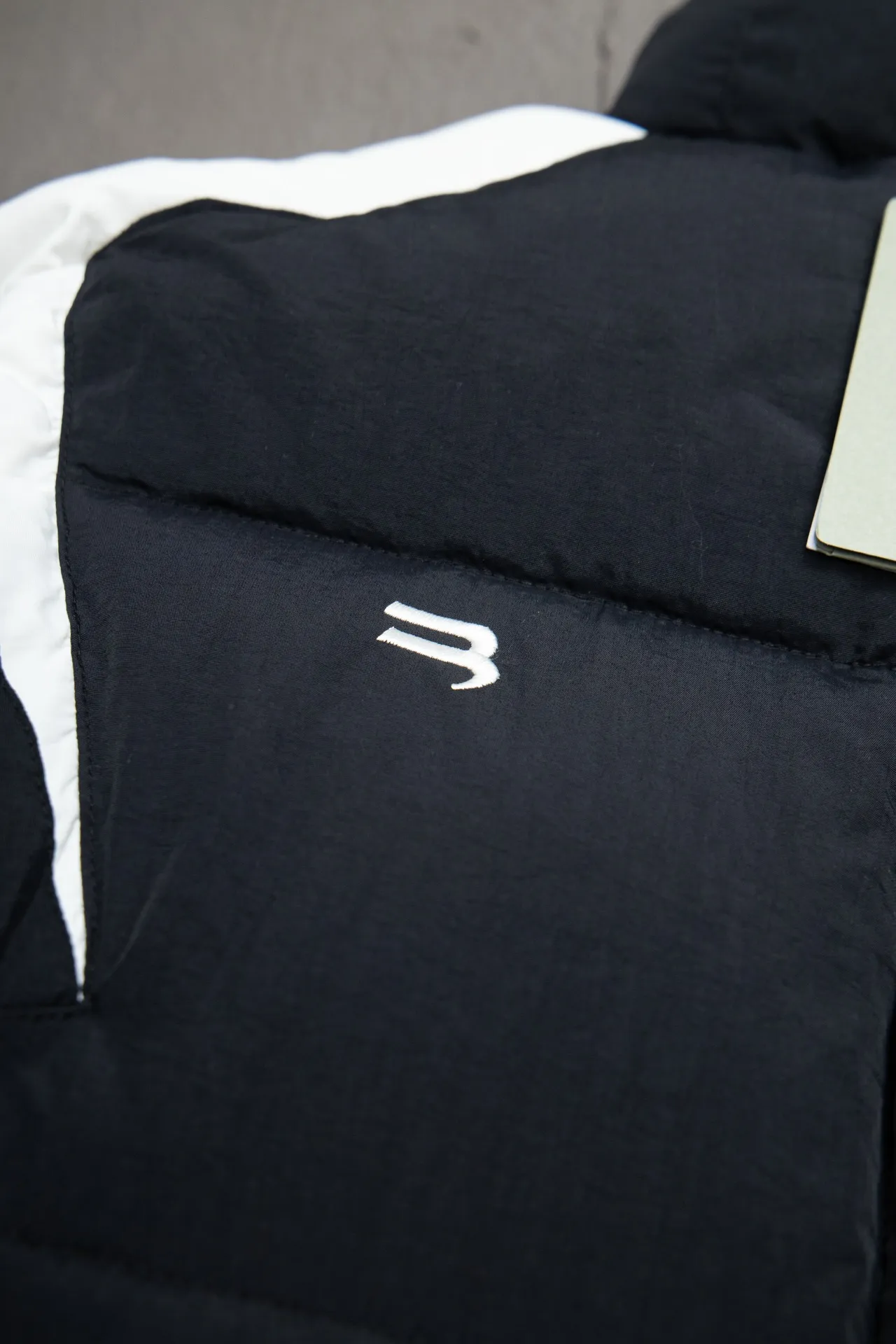 💰760 [Highest version, differentiated currency] Balenciaga / Balenciaga Blcg 24SS Manchester United football No. 10 black and white stitching joint stitching training down jacket, official website synchronized. The surface fabric and lining are made of customized high-density cloud-feel nylon fabric. The fabric has a level 4 water-repellent coating process. The lining is made of double-layer 330 gallbladder. Filled with 600 grams of Xinjiang pearl particle cotton. Extremely full!  The fabrics are the same as the original. Double-layer materials are used. The whole dress is full of style. Professional pattern makers from the original big-name OEM factory make patterns. Laser three-dimensional cutting. Because there are many splicing places, ordinary pattern makers are difficult to handle. Good products are made with care. Good goods take a long time. The whole body embroidery is operated by professional embroidery machines imported from island countries to make the embroidery details reach the top level. The whole body printing parts are operated using imported environmentally friendly offset printing technology. The printing is firm. The whole clothing accessories are molded and customized with hardware zippers and air holes. Double-hole limit buckle All have the same LOGO as the original version. Customized and washed as the original version. Main mark. Brand zipper seal bag. Brand LOGO moisture-proof paper. 3D laser cutting. Double-layer material. 5 meters of cloth for the whole piece. Extremely high cost. Composed of 47 pieces. Very slow production. Zipper pockets on both sides. Elastic cuff design. Imported environmentally friendly glue thermoset ink printing technology. Tajima high-speed embroidery machine embroidery Sporty B. Three-dimensional and full. The cuffs are equipped with new custom football embroidery patches. Customized hardware zippers. Double slider design. Customized original air holes. Customized original logo double-hole limit buckles. Original main mark and washed tag. Brand packaging. Color: black. Size: 46/48/50/52.