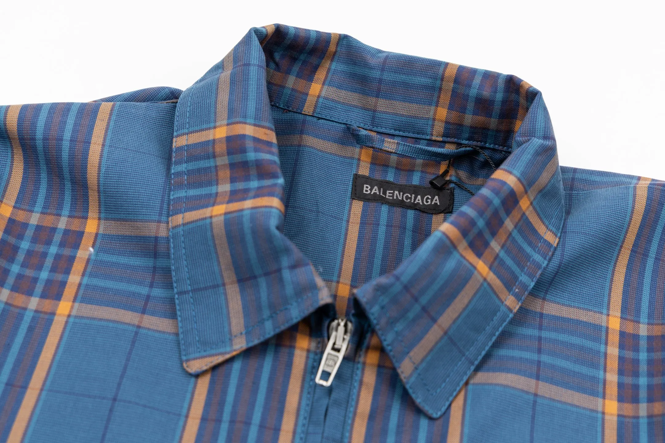 🅿️810 BLCG 25SS Blue Style Zippered Shirt Combining the delicate feel of jacquard fabric, the heavy feel of the double-layer structure and the functional feel of the zipper snap button, this item cleverly blurs the boundaries between shirts, jackets and lightweight coats. It not only retains the shape of a shirt, but also has the practical attributes of a jacket, making it very suitable as an outer layer in spring and autumn or as an inner layer in winter. Using double-layer composite jacquard technology, functional cotton yarns are three-dimensionally woven through an electronic jacquard machine. The plaid pattern is formed at once through the precise interweaving of warp and weft yarns during the weaving process, forming a permanent three-dimensional texture. The double-layer structure not only gives the fabric excellent stiffness and warmth retention properties, but also achieves temperature regulation through the air layer principle. Innovatively adopts the composite design of box-style straight cut and full zipper placket system. The straight hem provides a modern silhouette and ample layering space, while precision zippers replace traditional buttons, which not only enhances wind resistance but also creates smooth visual lines. The shoulders and armholes are three-dimensionally cut to ensure optimal freedom of movement despite the loose silhouette. The chest logo uses a jacquard letter logo to ensure the unity of decoration and function; the engraved four-button system is distributed on the cuffs, pockets and other locations to provide a precise closing experience; all seam interfaces have been strengthened to significantly enhance the durability and professional quality of the item. Size:XS-S-M-L