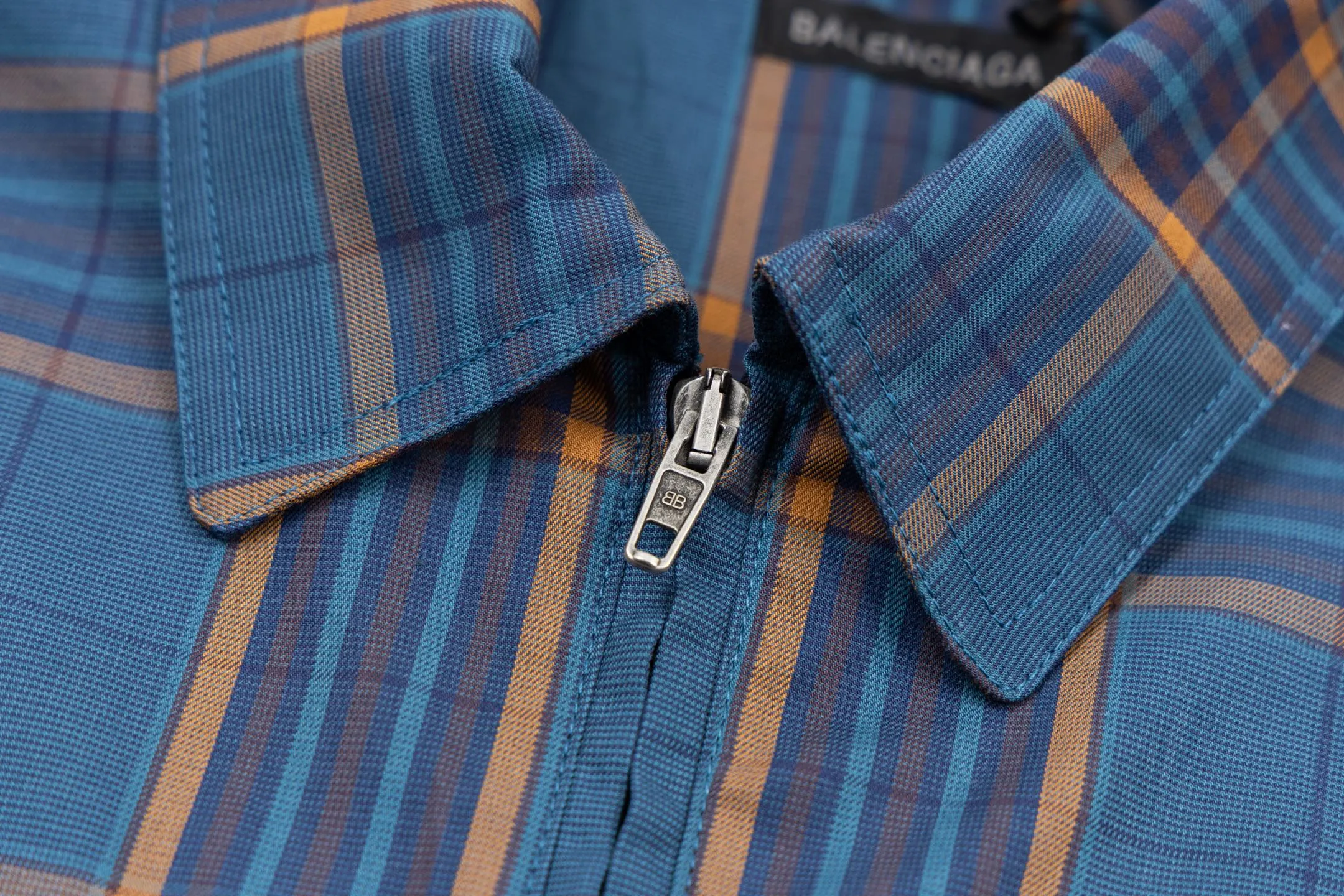 🅿️810 BLCG 25SS Blue Style Zippered Shirt Combining the delicate feel of jacquard fabric, the heavy feel of the double-layer structure and the functional feel of the zipper snap button, this item cleverly blurs the boundaries between shirts, jackets and lightweight coats. It not only retains the shape of a shirt, but also has the practical attributes of a jacket, making it very suitable as an outer layer in spring and autumn or as an inner layer in winter. Using double-layer composite jacquard technology, functional cotton yarns are three-dimensionally woven through an electronic jacquard machine. The plaid pattern is formed at once through the precise interweaving of warp and weft yarns during the weaving process, forming a permanent three-dimensional texture. The double-layer structure not only gives the fabric excellent stiffness and warmth retention properties, but also achieves temperature regulation through the air layer principle. Innovatively adopts the composite design of box-style straight cut and full zipper placket system. The straight hem provides a modern silhouette and ample layering space, while precision zippers replace traditional buttons, which not only enhances wind resistance but also creates smooth visual lines. The shoulders and armholes are three-dimensionally cut to ensure optimal freedom of movement despite the loose silhouette. The chest logo uses a jacquard letter logo to ensure the unity of decoration and function; the engraved four-button system is distributed on the cuffs, pockets and other locations to provide a precise closing experience; all seam interfaces have been strengthened to significantly enhance the durability and professional quality of the item. Size:XS-S-M-L