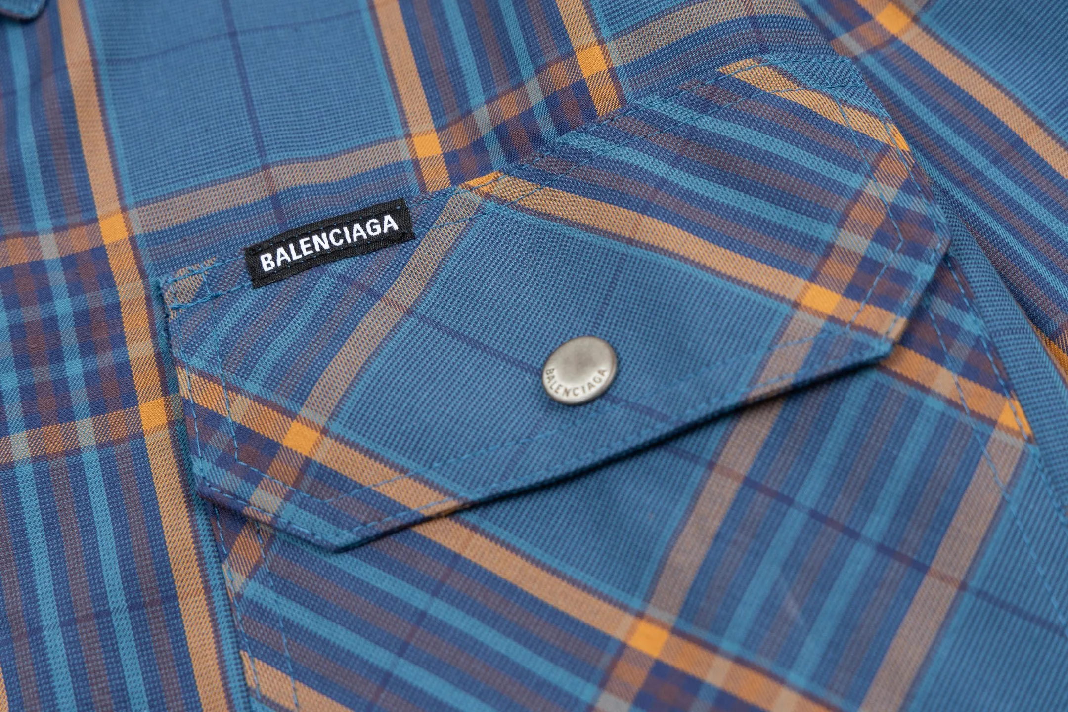 🅿️810 BLCG 25SS Blue Style Zippered Shirt Combining the delicate feel of jacquard fabric, the heavy feel of the double-layer structure and the functional feel of the zipper snap button, this item cleverly blurs the boundaries between shirts, jackets and lightweight coats. It not only retains the shape of a shirt, but also has the practical attributes of a jacket, making it very suitable as an outer layer in spring and autumn or as an inner layer in winter. Using double-layer composite jacquard technology, functional cotton yarns are three-dimensionally woven through an electronic jacquard machine. The plaid pattern is formed at once through the precise interweaving of warp and weft yarns during the weaving process, forming a permanent three-dimensional texture. The double-layer structure not only gives the fabric excellent stiffness and warmth retention properties, but also achieves temperature regulation through the air layer principle. Innovatively adopts the composite design of box-style straight cut and full zipper placket system. The straight hem provides a modern silhouette and ample layering space, while precision zippers replace traditional buttons, which not only enhances wind resistance but also creates smooth visual lines. The shoulders and armholes are three-dimensionally cut to ensure optimal freedom of movement despite the loose silhouette. The chest logo uses a jacquard letter logo to ensure the unity of decoration and function; the engraved four-button system is distributed on the cuffs, pockets and other locations to provide a precise closing experience; all seam interfaces have been strengthened to significantly enhance the durability and professional quality of the item. Size:XS-S-M-L
