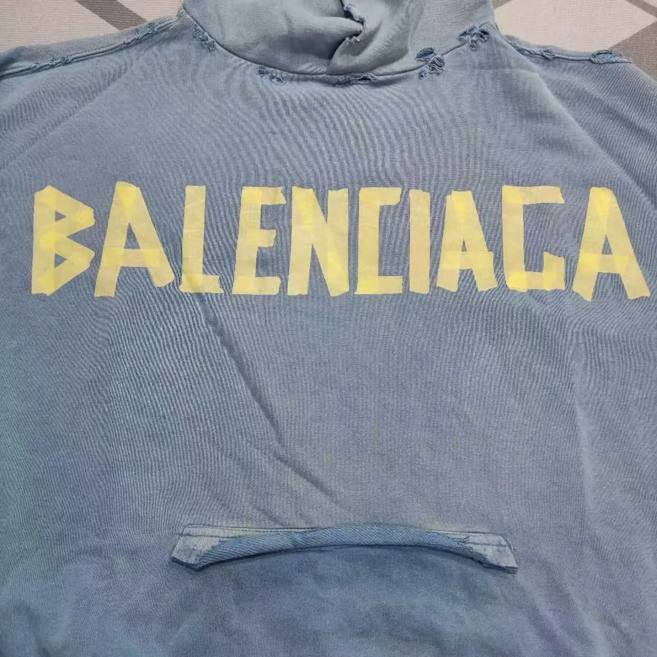 The top proven version of Balenciaga 23SS haze blue masking paper printed letters double-sided logo hooded loose hooded sweatshirt. This hoodie has a very interesting and cute design. The kangaroo pocket on the front of the large body is a reverse-cut design. The double side pockets are hollowed out, which actually deceives your vision when viewed from the front. The real pockets are sewn on the terry bottom on the reverse side. It is time-consuming and labor-intensive, but it is the core theme of the entire hoodie that cannot be ignored. In the same detail, the double side pockets are hemmed and stitched. And processed with holes; 480g heavy-weight pure cotton fabric with fine small terry bottom. After heavy mud dyeing and washing, the fabric still has a thick foundation and is comfortable and soft. The front and back double-sided textured paper transfer LOGO, and the front and back printing colors are different. The loose and large drop shoulder design is unisex. This style is also very suitable for girls to match. It is easy to create a lazy and casual street feel of the United States and France. Many holes are processed by hand grinding wheels on the body. Traces of muddying can be seen on the neckline, shoulder line, and side cuff splicing, but the visual effect transition is natural and soft without any sense of dirt. The old effect of the entire hoodie is excellent. The cuff threads are custom-woven in color; the packaging is washed and customized. The new gray silver letter main logo. The dropped shoulder model does not include shoulder width. The version is Kanye’s American style. Short and wide street casual version. From short sleeves to sweaters, this style is definitely not to be missed. Color: mud-dyed custom-woven navy Size: XS-S-M (Can be worn by both men and women, OS is loose and dropped on the shoulders) P:510