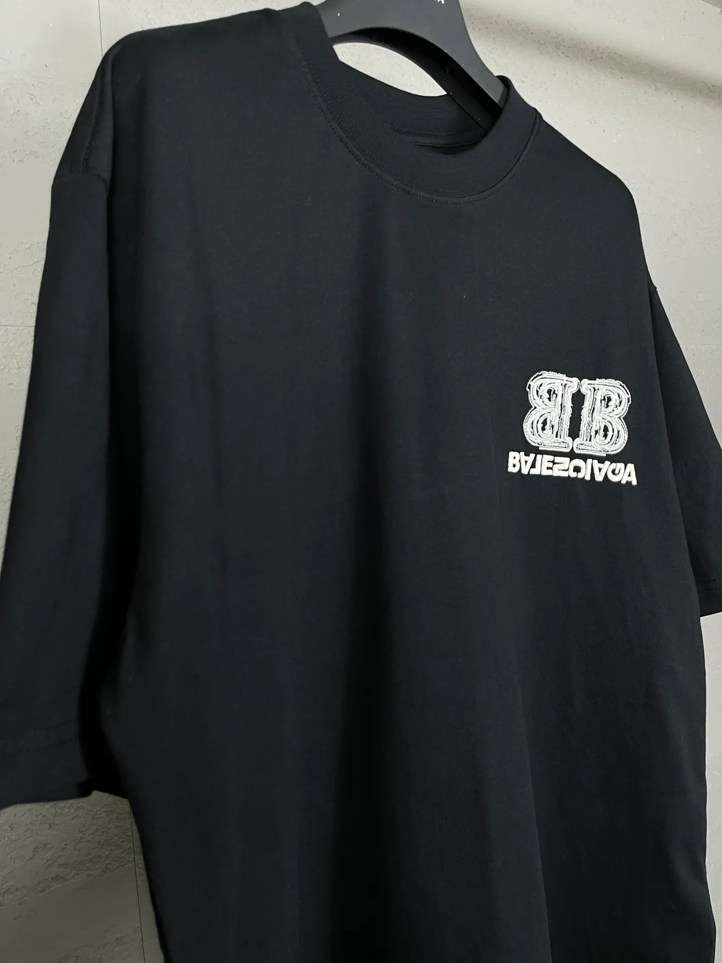 🅿️200 Actual pictures [Top version. Official website quality] BALENCI*GA/Paris BALENCI*GA# New style, BB reverse letter embroidery letters large LOGO short-sleeved T-shirt. More than 200,000 needles are used to embroider the logo letters on the front and back of the chest. Welcome to compare! The fabric is made of Paris ZP custom-woven and dyed 100% cotton double-yarn compact cotton. The weight is 260 grams. The cloth surface is clean. The cloth pattern is clear. It is soft and comfortable. It has good color fastness and is not easy to change color. The threads are woven and dyed with no color difference. The embroidery is done using imported Tajima embroidery machines. Super 15W needle thread embroidery, accurate positioning, three-dimensional effect, clear lines. No burrs and miscellaneous threads, ultra-high craftsmanship embroidery. The version adopts OS loose shoulder design. Same style for men and women. Code: BL223208 Color: black. Size: XS to L
