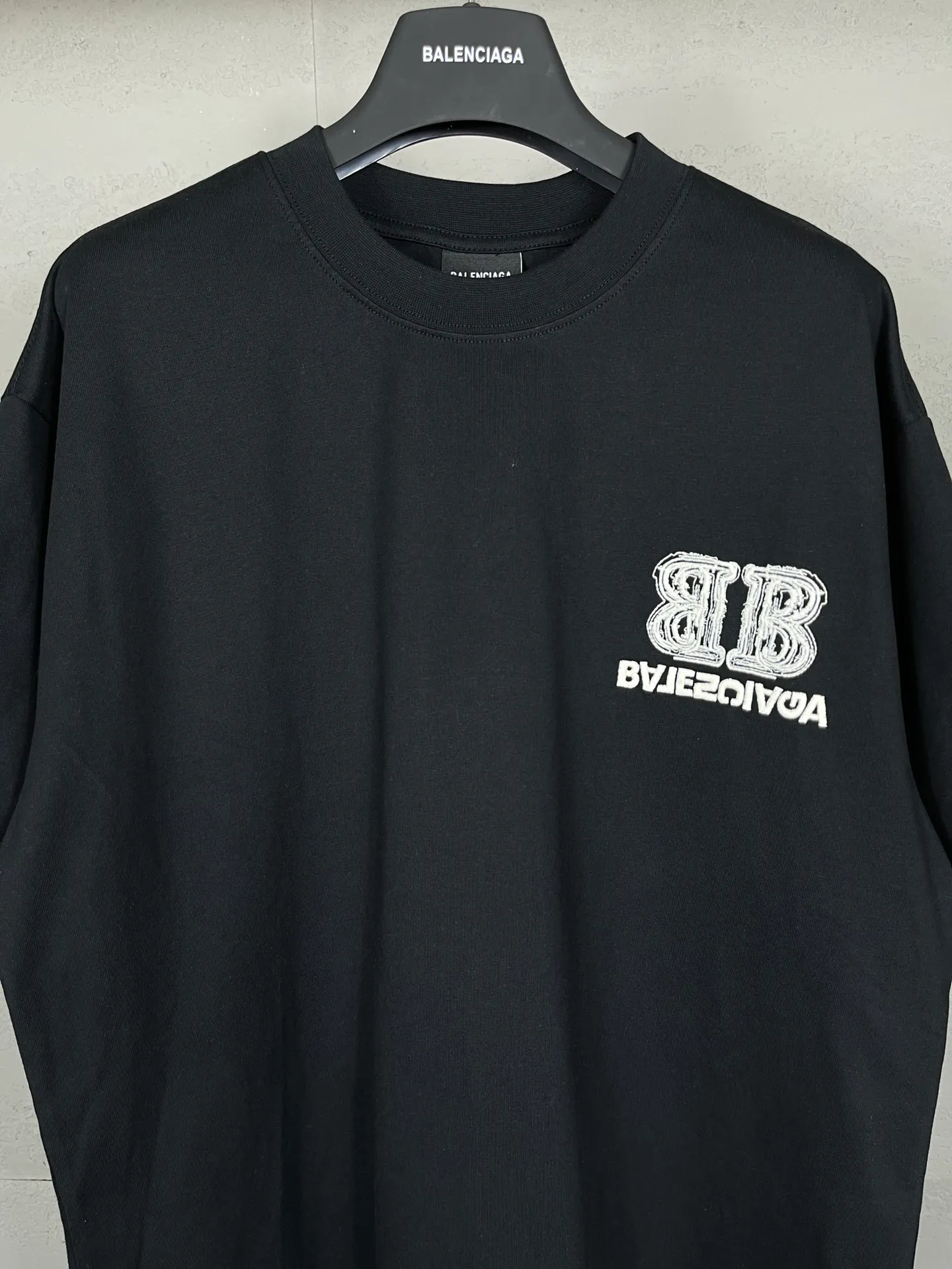 🅿️200 Actual pictures [Top version. Official website quality] BALENCI*GA/Paris BALENCI*GA# New style, BB reverse letter embroidery letters large LOGO short-sleeved T-shirt. More than 200,000 needles are used to embroider the logo letters on the front and back of the chest. Welcome to compare! The fabric is made of Paris ZP custom-woven and dyed 100% cotton double-yarn compact cotton. The weight is 260 grams. The cloth surface is clean. The cloth pattern is clear. It is soft and comfortable. It has good color fastness and is not easy to change color. The threads are woven and dyed with no color difference. The embroidery is done using imported Tajima embroidery machines. Super 15W needle thread embroidery, accurate positioning, three-dimensional effect, clear lines. No burrs and miscellaneous threads, ultra-high craftsmanship embroidery. The version adopts OS loose shoulder design. Same style for men and women. Code: BL223208 Color: black. Size: XS to L