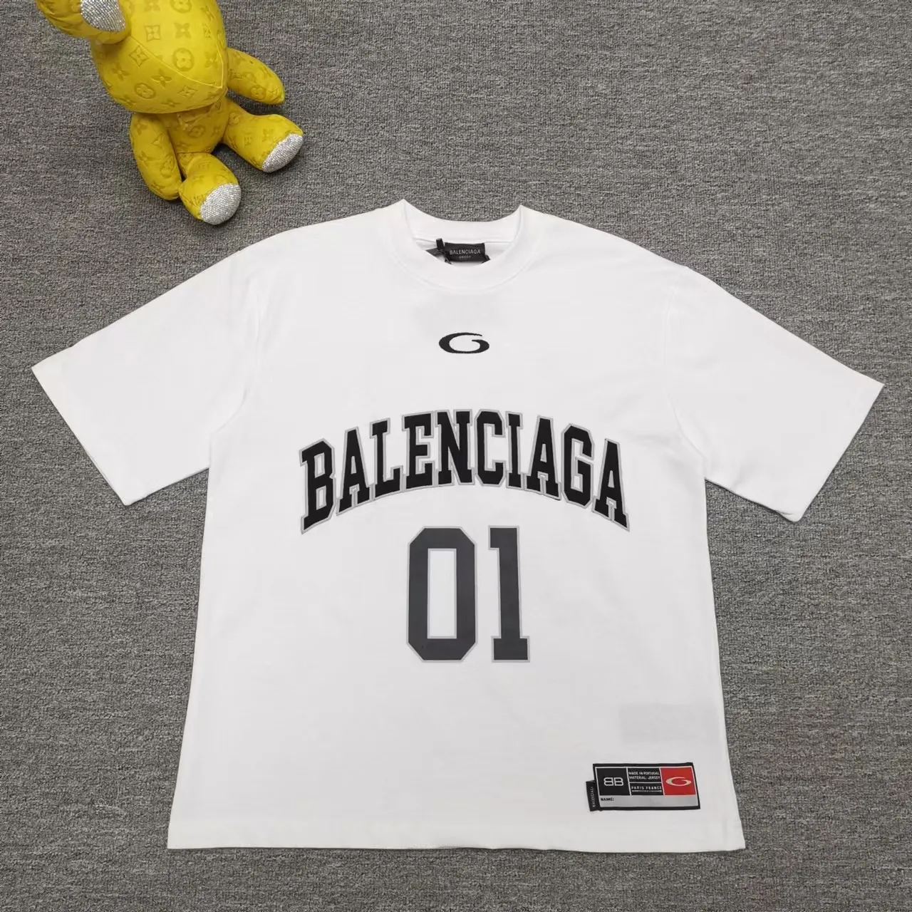 Top version Balenciaga SS25 Front letter embroidery Printed round neck short-sleeved T-shirt High weight double yarn pure cotton fabric Loose version Purchase the original pattern and make a sample. Compare the original fabric, version and details. Fabric: 100% cotton fabric is used, and imported cotton yarn is used. Soft, skin-friendly and non-irritating.  Craftsmanship: The clothing is a front-shoulder version, and all pieces are cut one-to-one by professional masters. Details: All accessories are genuine one-to-one custom-made and fully equipped, including the buttons on the front of the clothing.  Purchase the original benchmarking details fabric, high version, heavy weight 320g double yarn pure cotton fabric, color: blue, black, white, code number: XS S M L P: 310