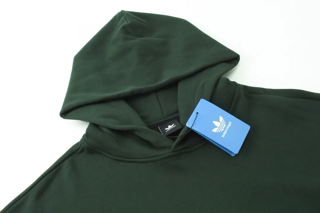 🅿️300 Detailed picture [Top version. Official website quality] BALENCI*GA/Paris co-branded Adidas embroidered front LOGO long-sleeved hooded sweatshirt. The fabric is made of Paris ZP custom-woven and dyed cotton sweatshirt. The weight is 450 grams, the cloth surface is clean. The cloth pattern is clear, soft and comfortable. The color fastness is good. It is not easy to change color. The threads are dyed with no color difference. The LOGO pattern letters are embroidered using imported embroidery machines, and the letters are three-dimensional and full. It is produced in Jubie market based on pictures, and comparisons are welcome. Restored brick cabinets. The version adopts OS loose shoulder design. Same style for men and women. Code: BL238017 Color: dark green, black Size: XS S M L