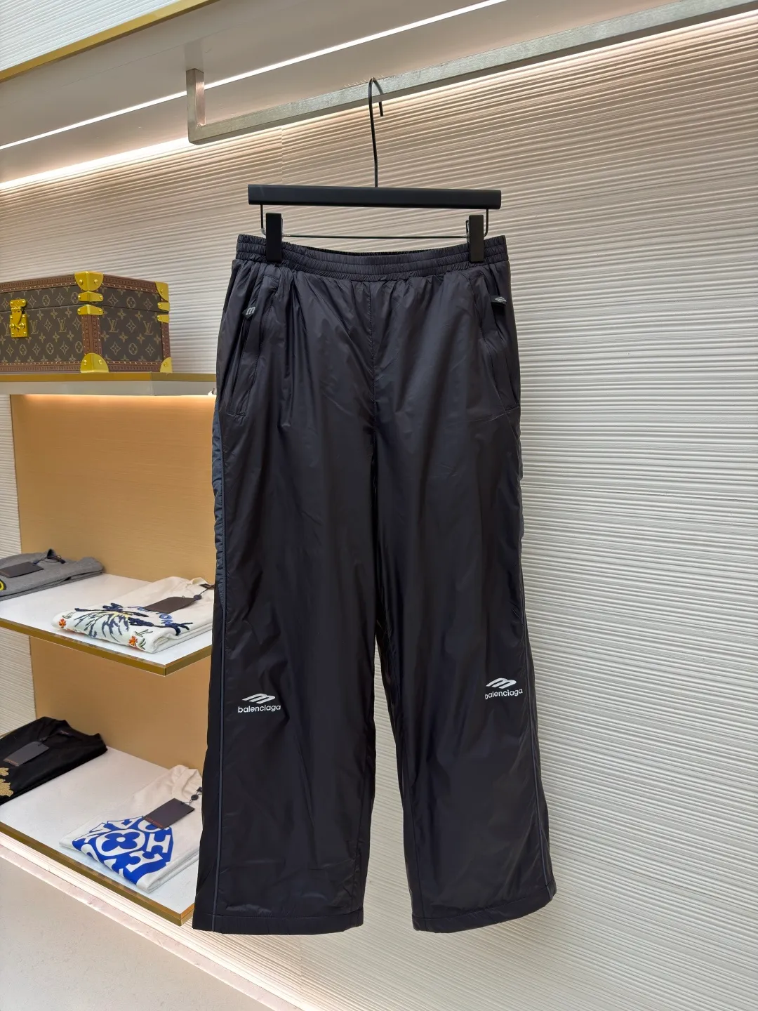 Balenciaga SKIWEAR series 3B printed fleece ski pants ●Original version: purchased and developed by 12414 ●Item number: 1682492-B25 ●Fabric: nylon fabric ●Technology: printing production ●Color: black ●Version: fitted version ●Weight: about 415 grams ●Size: S-M-L-XL ●Description: High-density technological nylon fiber is selected, and a delicate matte texture is created through a special textile process. The black tone presents a low-key and high-end visual effect. The fabric is lightweight yet stiff, has excellent wrinkle resistance and abrasion resistance, and is not prone to pilling or deformation for daily wear. It also has certain windproof properties to cope with changeable weather. The inner lining is made of high-density fluff material with excellent fluffiness and elasticity. When it closely fits the skin, it can form a layer of warm air, effectively locking in heat and improving the warmth factor of winter wear. The down fiber is delicate and smooth, avoiding the rough feeling of traditional plush fabrics, achieving the dual experience of "lightness and no burden" and "constant temperature and warmth", taking into account both comfort and practicality. Imported silicone printing technology is used on both sides of the trouser legs to present the iconic 3B sports icon pattern in a relief-like three-dimensional form. The silicone material has been pressed at high temperature and is tightly integrated with the fabric, making it difficult to fall off and crack. At the same time, it retains a delicate matte luster, forming a subtle texture contrast with the pants fabric, highlighting the brand recognition in a low-key manner. The mid-waist design is equipped with a double-layer elastic rib waistband and a built-in adjustable drawstring. The elastic fiber at the waistband has been pre-shrunk to ensure that it is not easy to loosen after long-term wear. It can not only stabilize the waist shape, but also adapt to the activity needs of different body shapes, taking into account sports functionality and daily comfort. The overall wiring is straight and delicate, the fabric is comfortable and soft, and the color is consistent without color difference. It can be matched with the same style to create a fashionable look and control various occasions. Customized accessories, complete with three standards, same style for men and women!