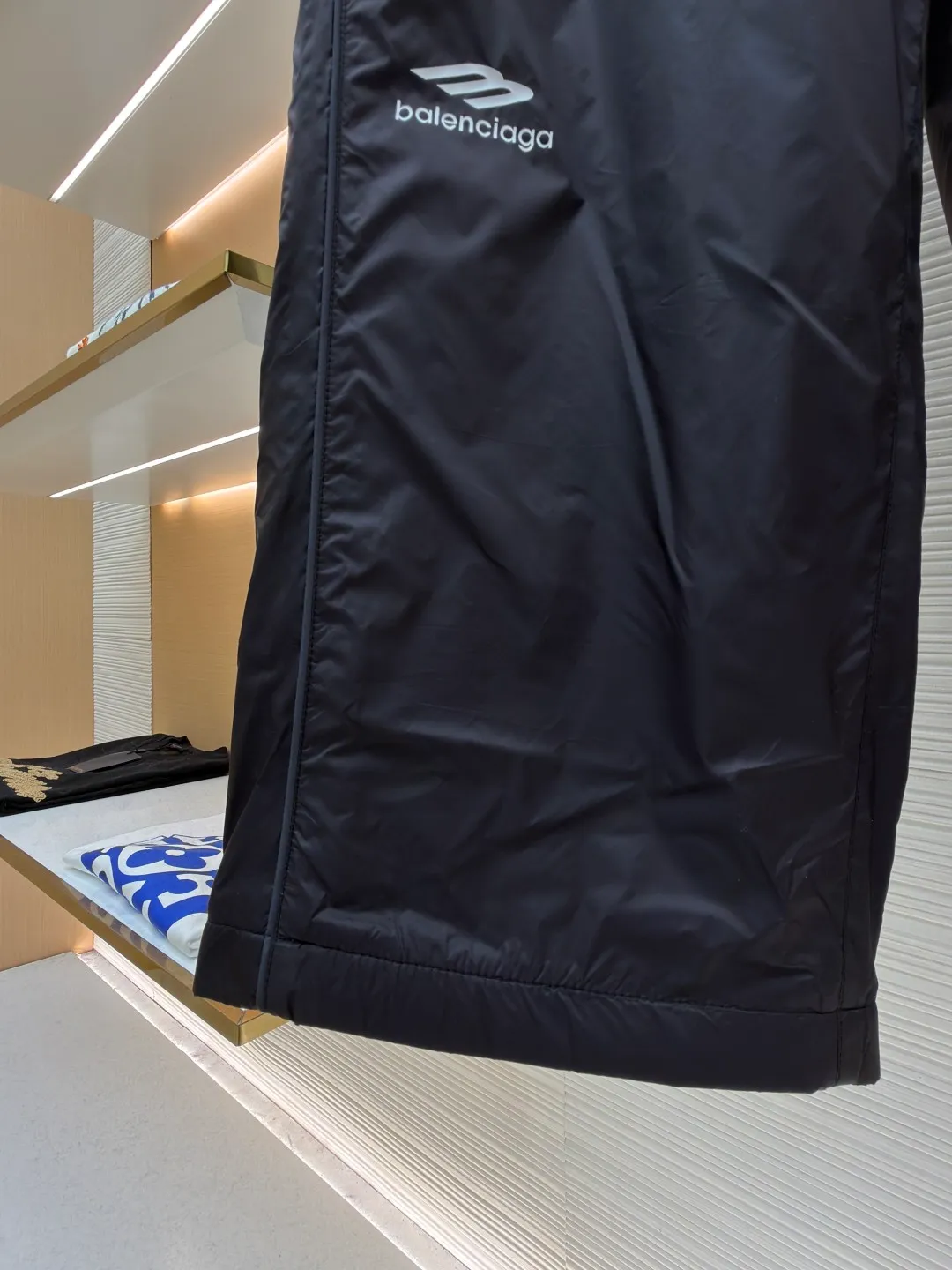 Balenciaga SKIWEAR series 3B printed fleece ski pants ●Original version: purchased and developed by 12414 ●Item number: 1682492-B25 ●Fabric: nylon fabric ●Technology: printing production ●Color: black ●Version: fitted version ●Weight: about 415 grams ●Size: S-M-L-XL ●Description: High-density technological nylon fiber is selected, and a delicate matte texture is created through a special textile process. The black tone presents a low-key and high-end visual effect. The fabric is lightweight yet stiff, has excellent wrinkle resistance and abrasion resistance, and is not prone to pilling or deformation for daily wear. It also has certain windproof properties to cope with changeable weather. The inner lining is made of high-density fluff material with excellent fluffiness and elasticity. When it closely fits the skin, it can form a layer of warm air, effectively locking in heat and improving the warmth factor of winter wear. The down fiber is delicate and smooth, avoiding the rough feeling of traditional plush fabrics, achieving the dual experience of "lightness and no burden" and "constant temperature and warmth", taking into account both comfort and practicality. Imported silicone printing technology is used on both sides of the trouser legs to present the iconic 3B sports icon pattern in a relief-like three-dimensional form. The silicone material has been pressed at high temperature and is tightly integrated with the fabric, making it difficult to fall off and crack. At the same time, it retains a delicate matte luster, forming a subtle texture contrast with the pants fabric, highlighting the brand recognition in a low-key manner. The mid-waist design is equipped with a double-layer elastic rib waistband and a built-in adjustable drawstring. The elastic fiber at the waistband has been pre-shrunk to ensure that it is not easy to loosen after long-term wear. It can not only stabilize the waist shape, but also adapt to the activity needs of different body shapes, taking into account sports functionality and daily comfort. The overall wiring is straight and delicate, the fabric is comfortable and soft, and the color is consistent without color difference. It can be matched with the same style to create a fashionable look and control various occasions. Customized accessories, complete with three standards, same style for men and women!
