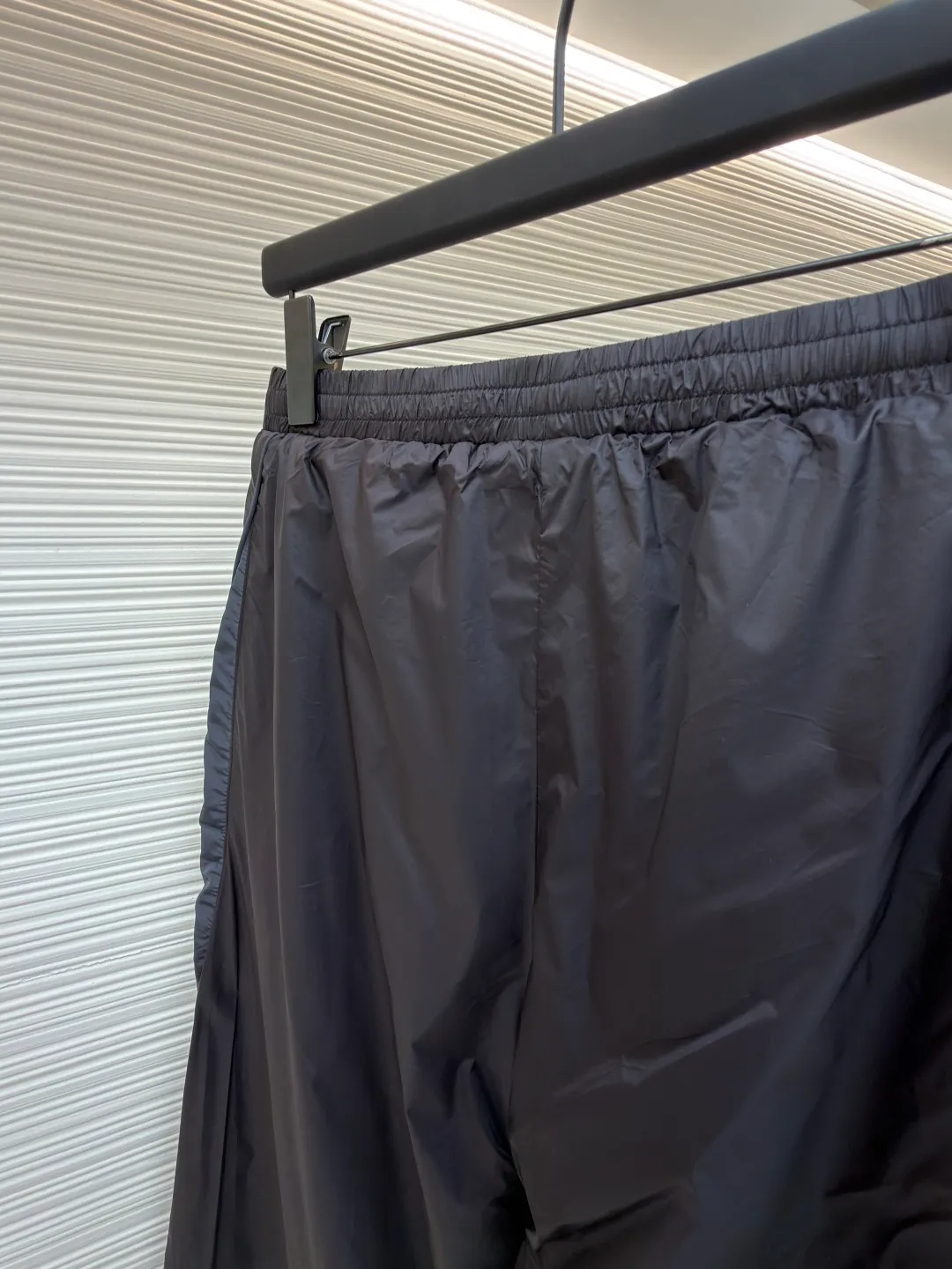 Balenciaga SKIWEAR series 3B printed fleece ski pants ●Original version: purchased and developed by 12414 ●Item number: 1682492-B25 ●Fabric: nylon fabric ●Technology: printing production ●Color: black ●Version: fitted version ●Weight: about 415 grams ●Size: S-M-L-XL ●Description: High-density technological nylon fiber is selected, and a delicate matte texture is created through a special textile process. The black tone presents a low-key and high-end visual effect. The fabric is lightweight yet stiff, has excellent wrinkle resistance and abrasion resistance, and is not prone to pilling or deformation for daily wear. It also has certain windproof properties to cope with changeable weather. The inner lining is made of high-density fluff material with excellent fluffiness and elasticity. When it closely fits the skin, it can form a layer of warm air, effectively locking in heat and improving the warmth factor of winter wear. The down fiber is delicate and smooth, avoiding the rough feeling of traditional plush fabrics, achieving the dual experience of "lightness and no burden" and "constant temperature and warmth", taking into account both comfort and practicality. Imported silicone printing technology is used on both sides of the trouser legs to present the iconic 3B sports icon pattern in a relief-like three-dimensional form. The silicone material has been pressed at high temperature and is tightly integrated with the fabric, making it difficult to fall off and crack. At the same time, it retains a delicate matte luster, forming a subtle texture contrast with the pants fabric, highlighting the brand recognition in a low-key manner. The mid-waist design is equipped with a double-layer elastic rib waistband and a built-in adjustable drawstring. The elastic fiber at the waistband has been pre-shrunk to ensure that it is not easy to loosen after long-term wear. It can not only stabilize the waist shape, but also adapt to the activity needs of different body shapes, taking into account sports functionality and daily comfort. The overall wiring is straight and delicate, the fabric is comfortable and soft, and the color is consistent without color difference. It can be matched with the same style to create a fashionable look and control various occasions. Customized accessories, complete with three standards, same style for men and women!